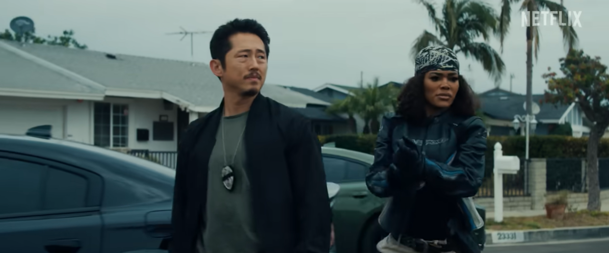 Detectives Mike Ro and Numa Baptiste, played by Steven Yeun and Teyana Taylor, survey a scene in "The Rip" | Source: YouTube/Netflix