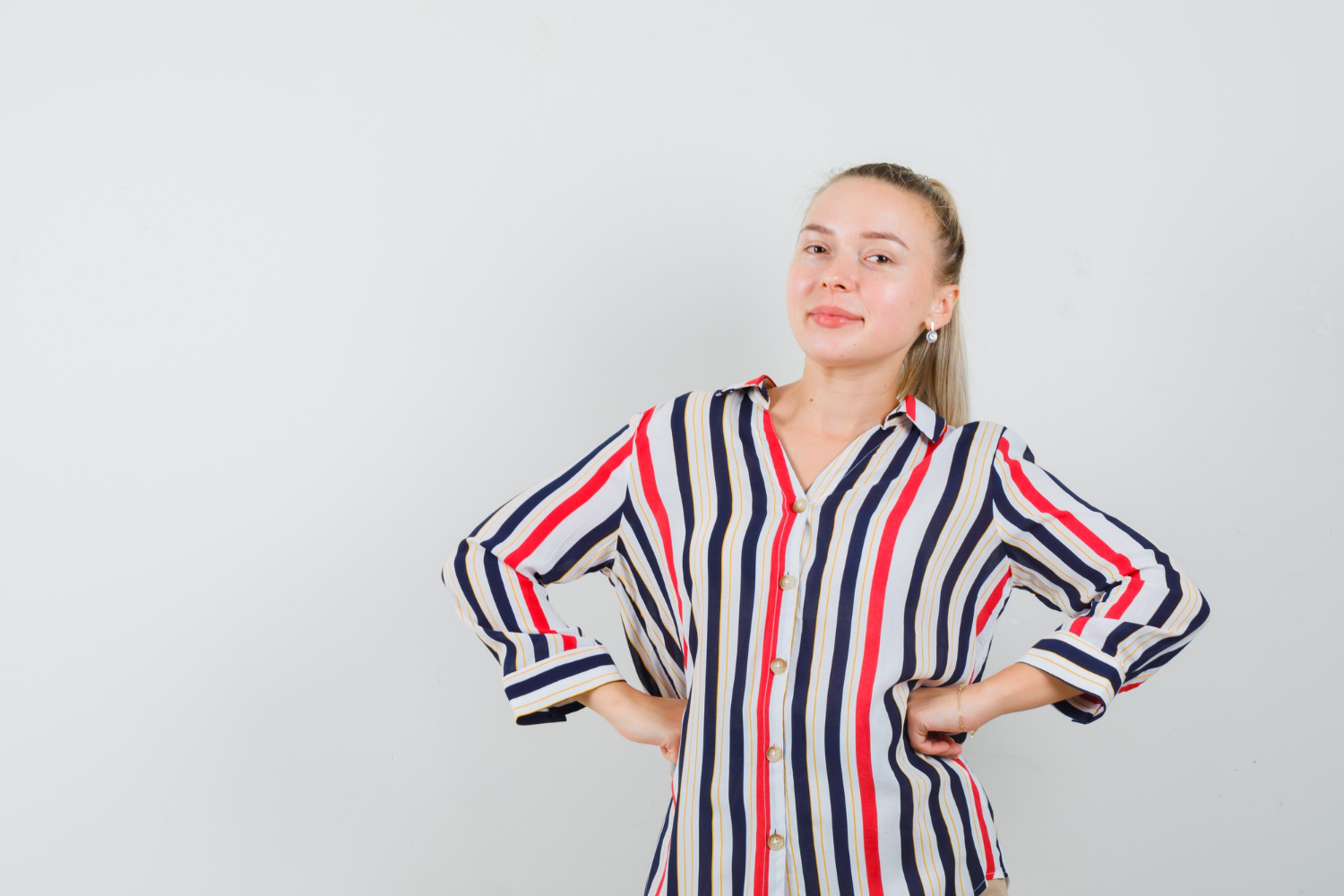 A smiling woman with her hands on her hips | Source: Freepik