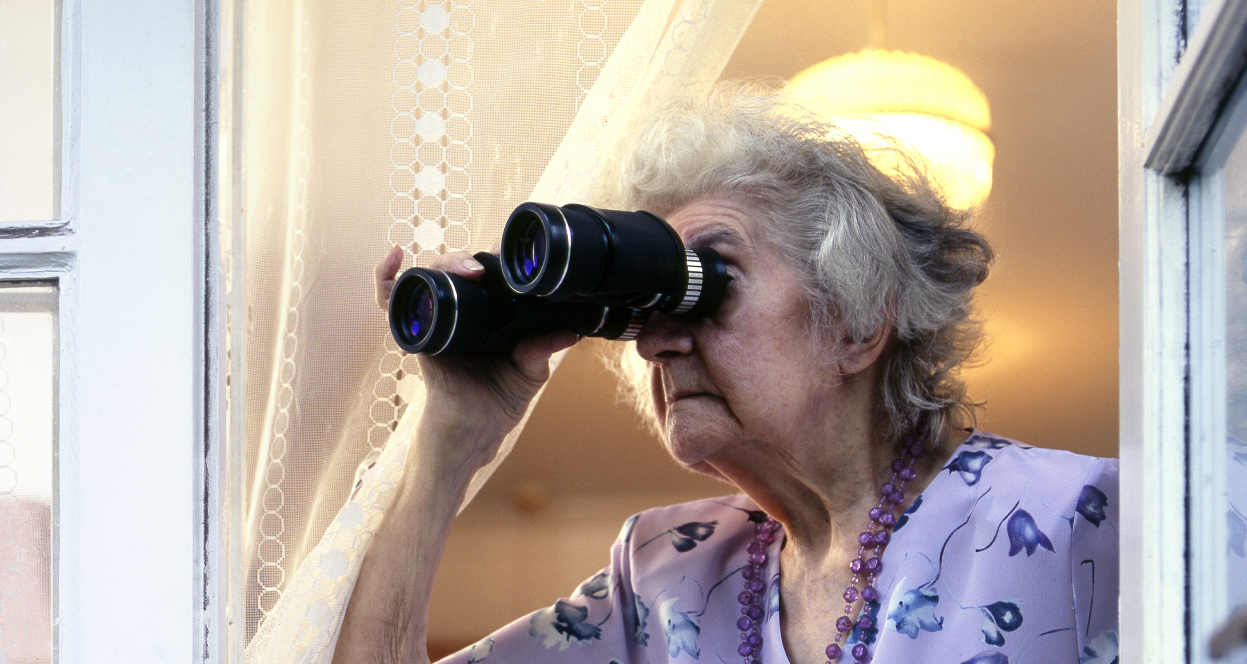 Senior woman looking through binoculars | Source: Getty Images