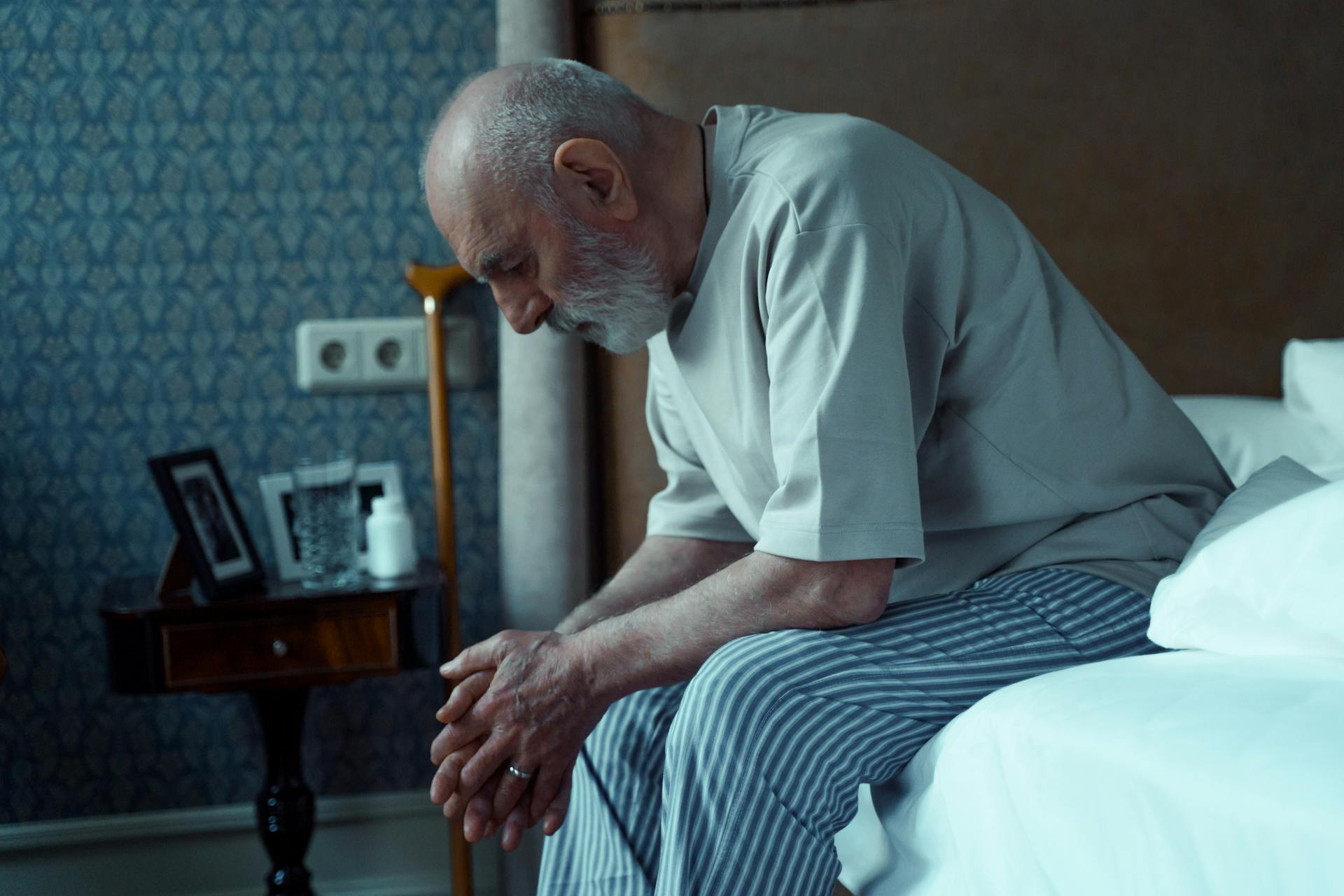 An elderly man sitting on his bed | Source: Pexels