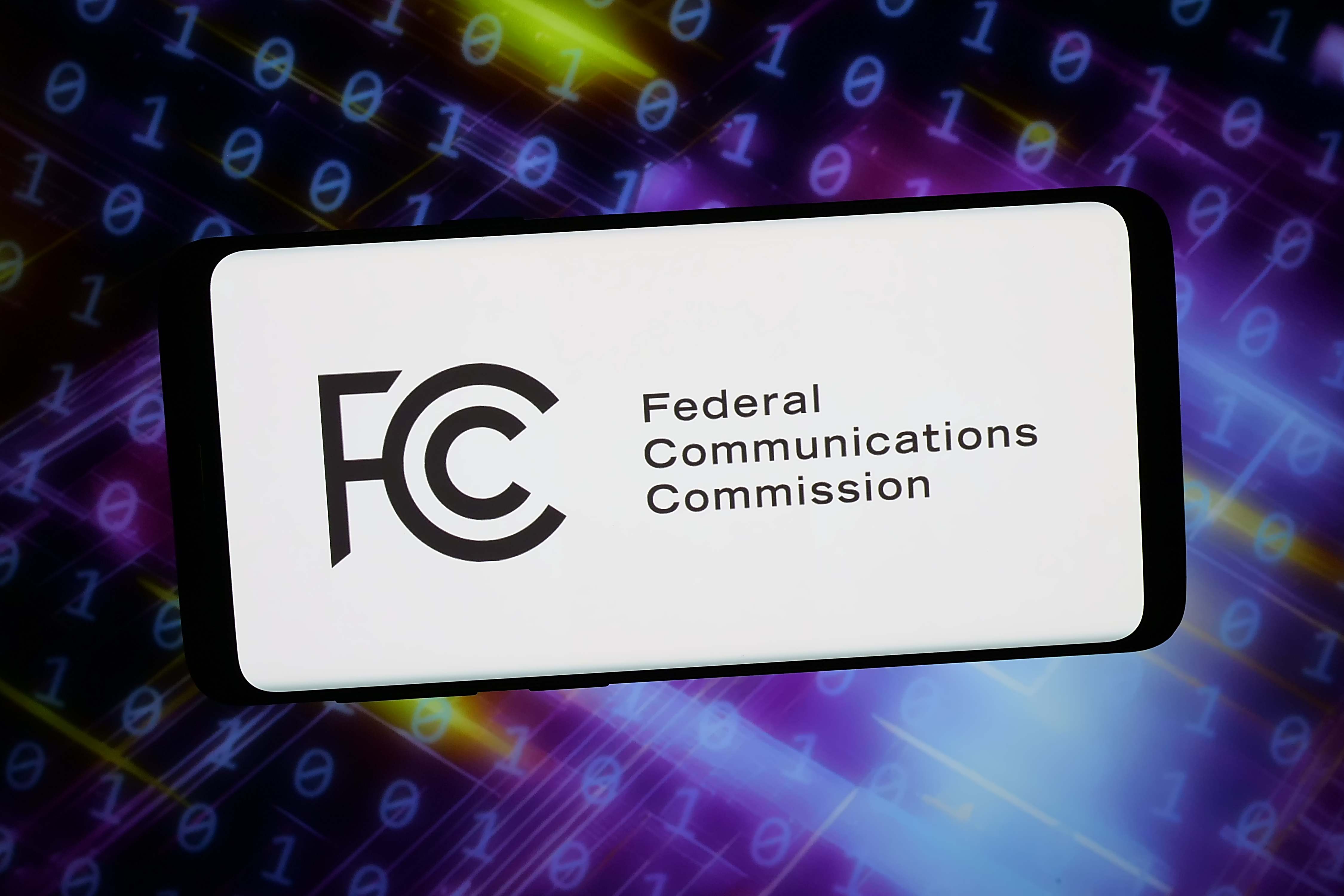 In this photo illustration, the agency Federal Communications Commission logo is seen displayed on a smartphone in front of abstract background on computer screen in Germany on February 20, 2026 | Source: Getty Images