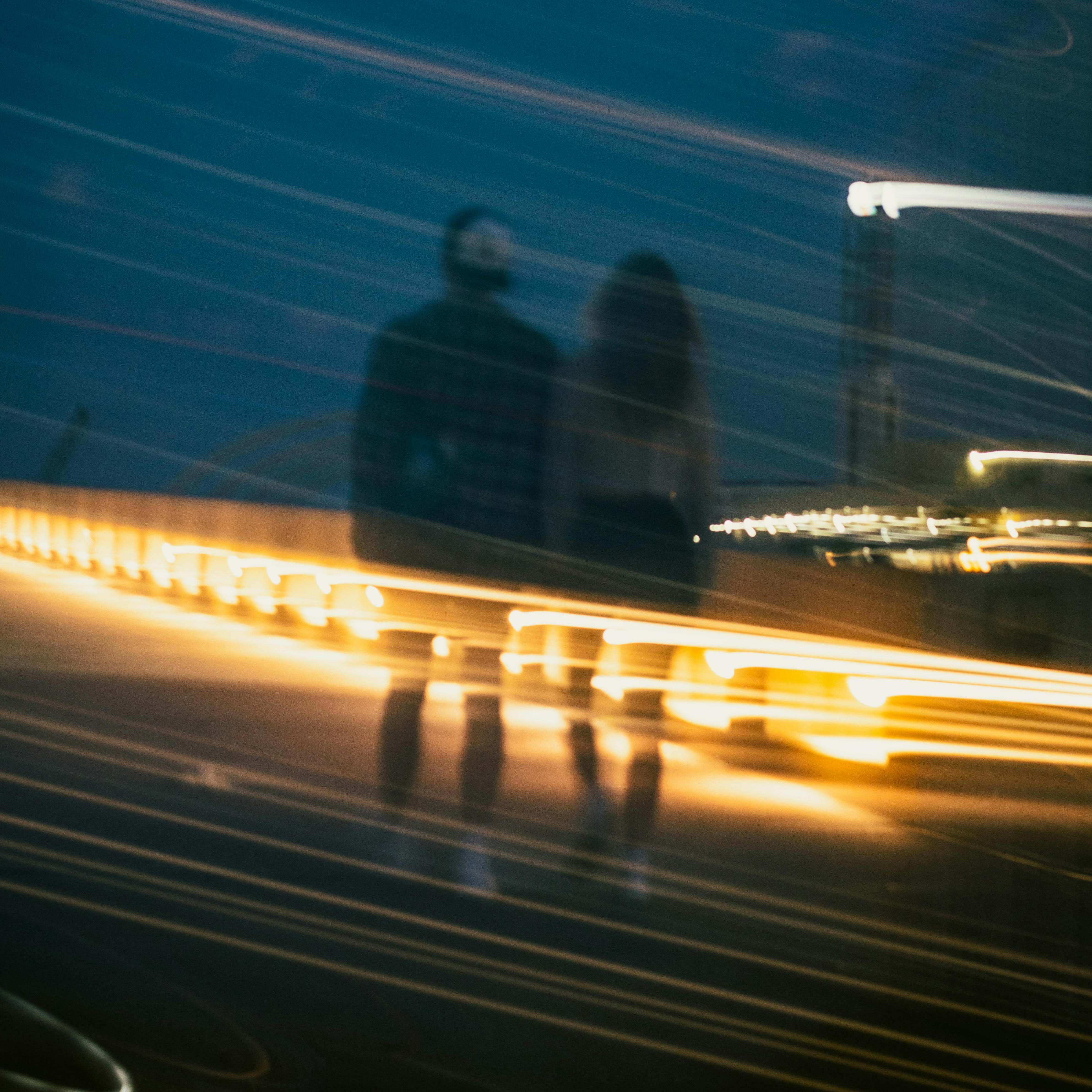 A man and woman walking side-by-side down a street at night | Source: Pexels