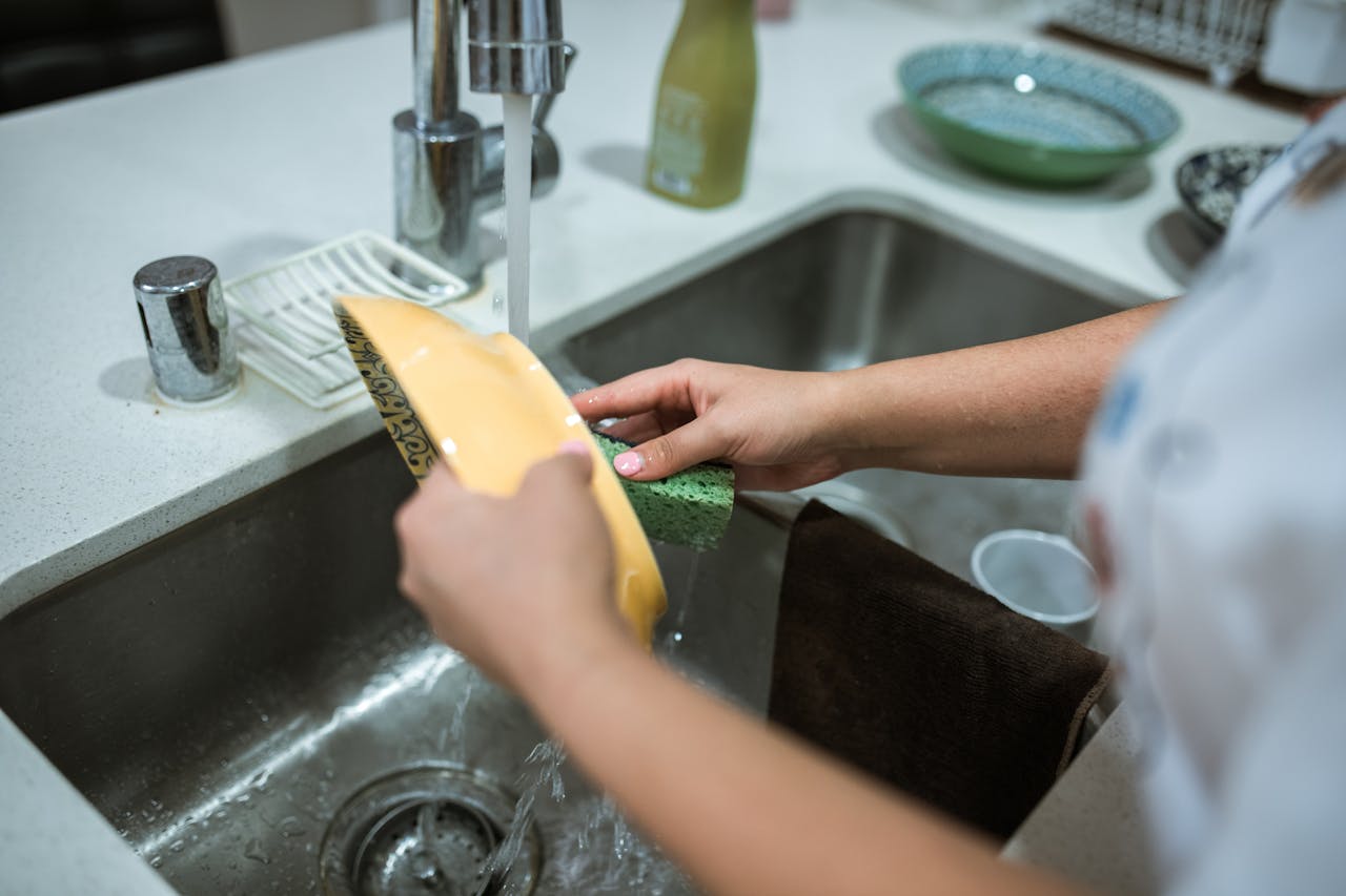 A teenage girl washing vessels | Source: Pexels