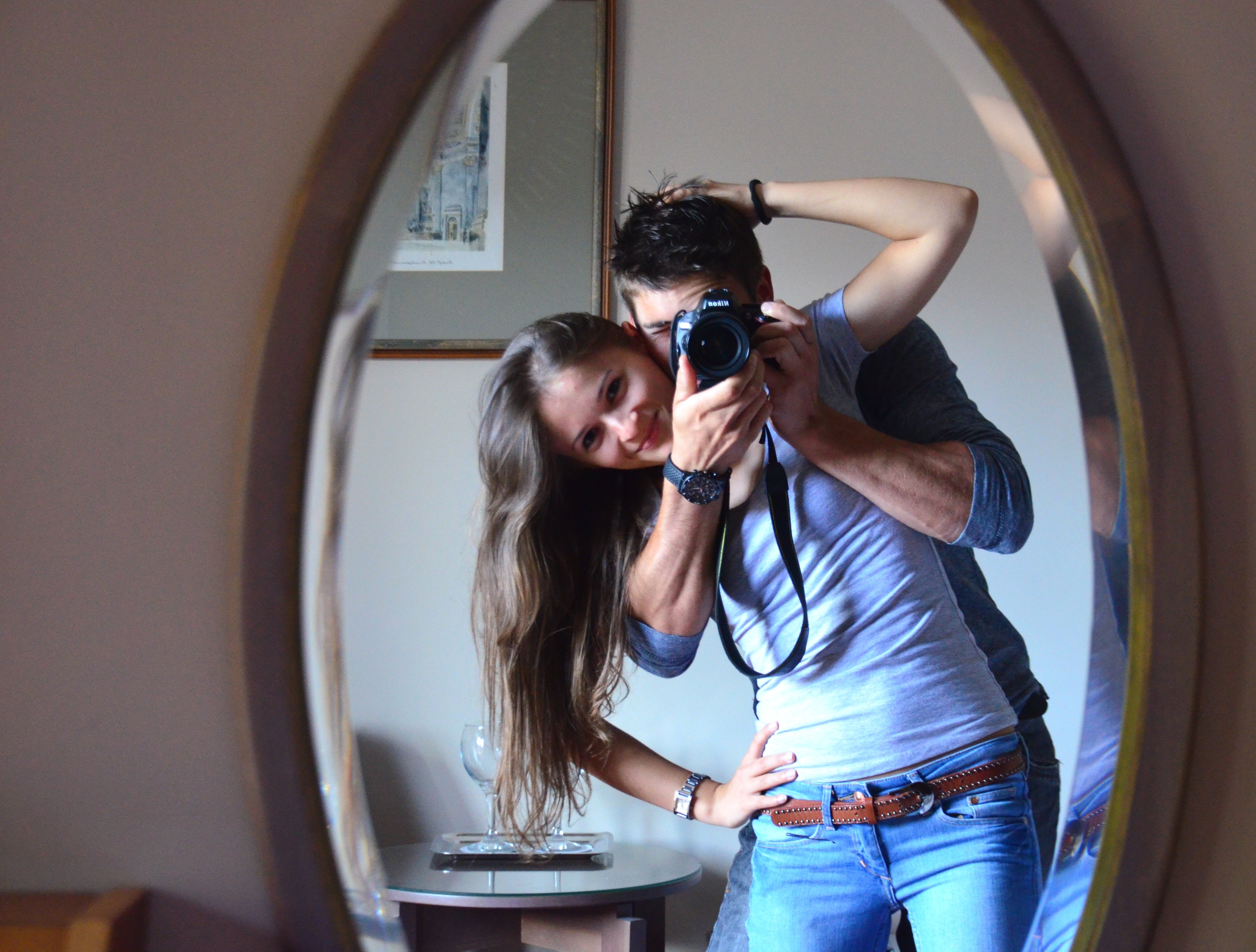 A couple takes a photo infront of a mirror. | Source: Pexels
