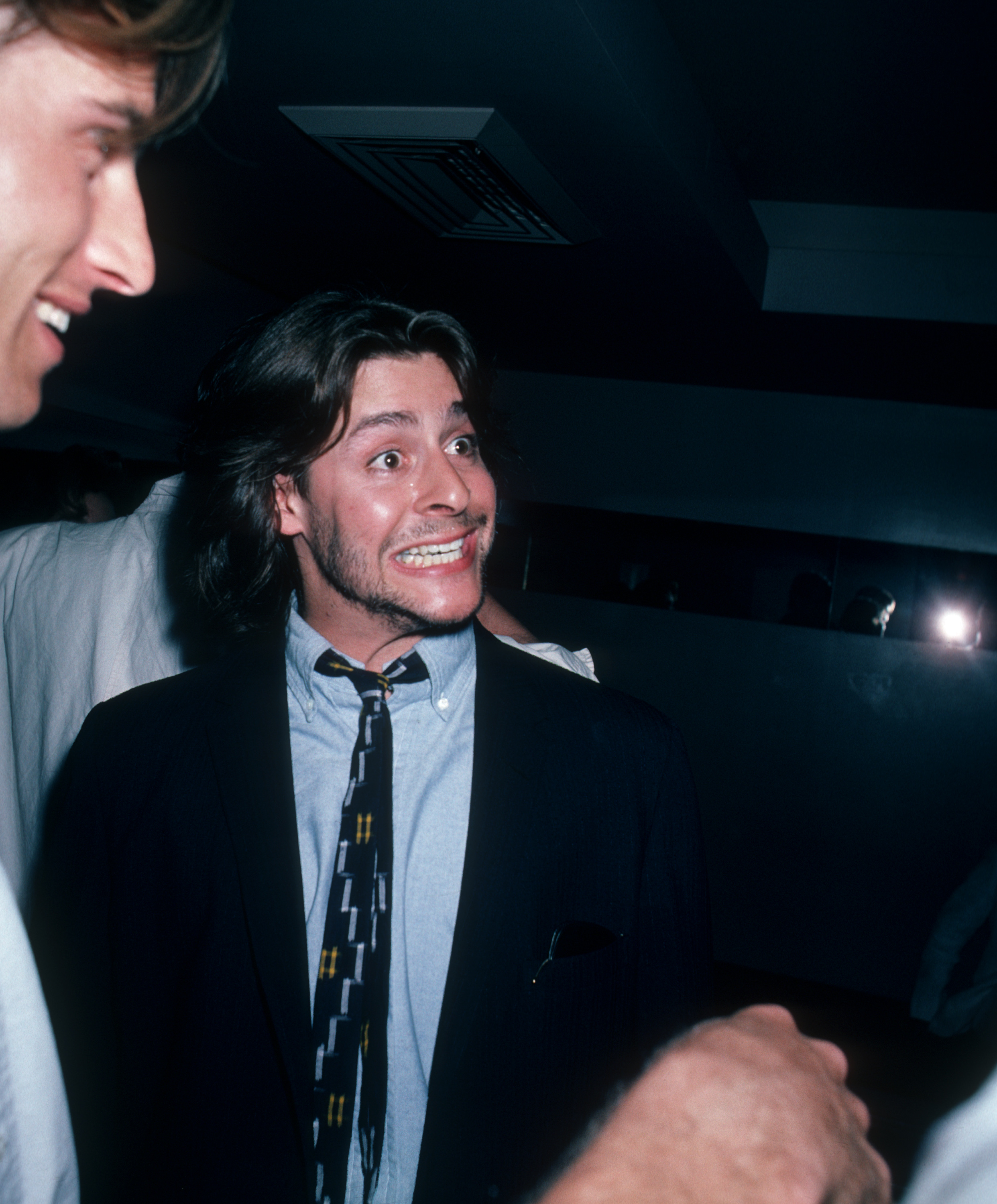 Striking an animated, wide-eyed expression during a lively conversation, the actor enjoyed a night out at the Peter Max Art Exhibit at Marylou's in New York City on May 8, 1986. | Source: Getty Images