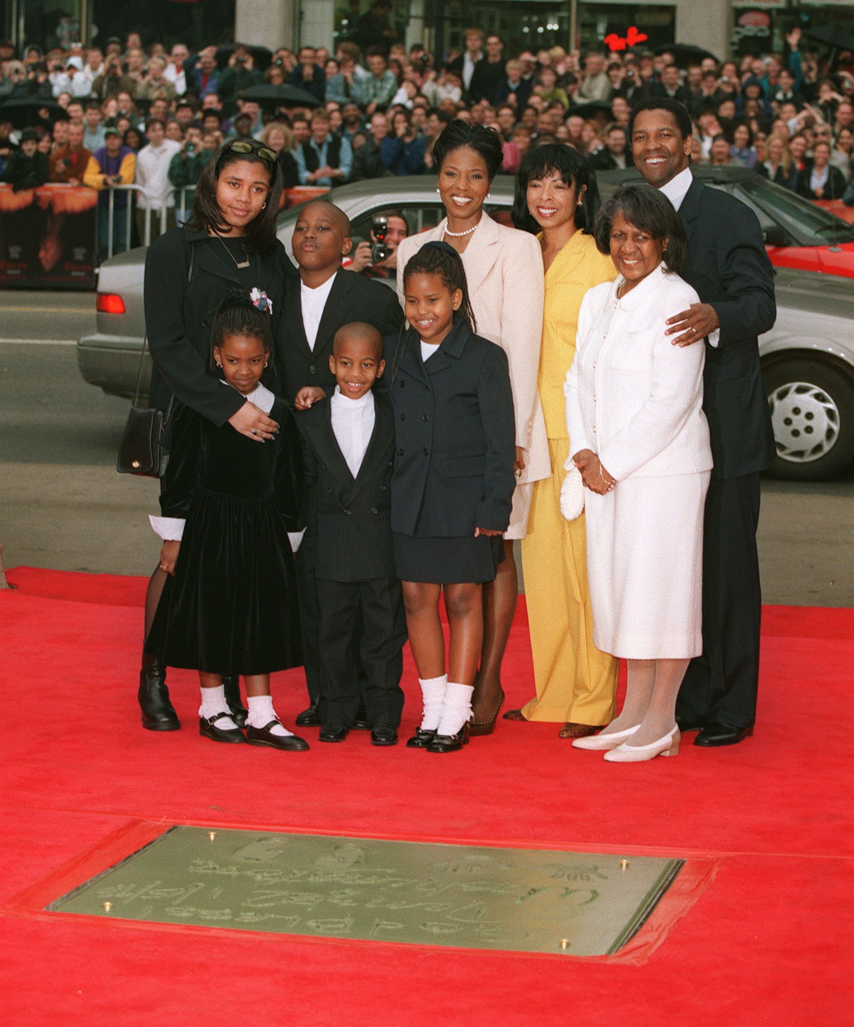 El actor Denzel Washington y su esposa, la actriz Pauletta Washington, fotografiados con sus hijos y familiares en la Ceremonia de la Huella de Washington el 16 de enero de 1998 ┃Foto: Getty Images
