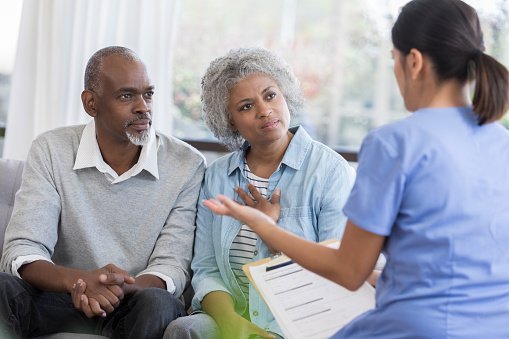 A doctor talking to an old couple.| Photo: Getty Images.