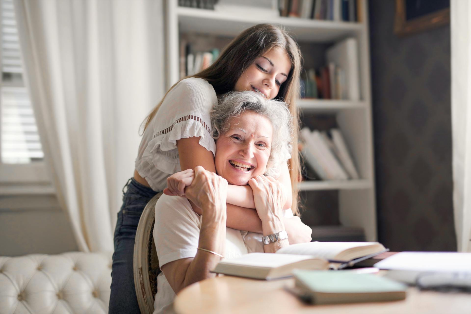 A girl hugging her grandma from behind | Source: Pexels