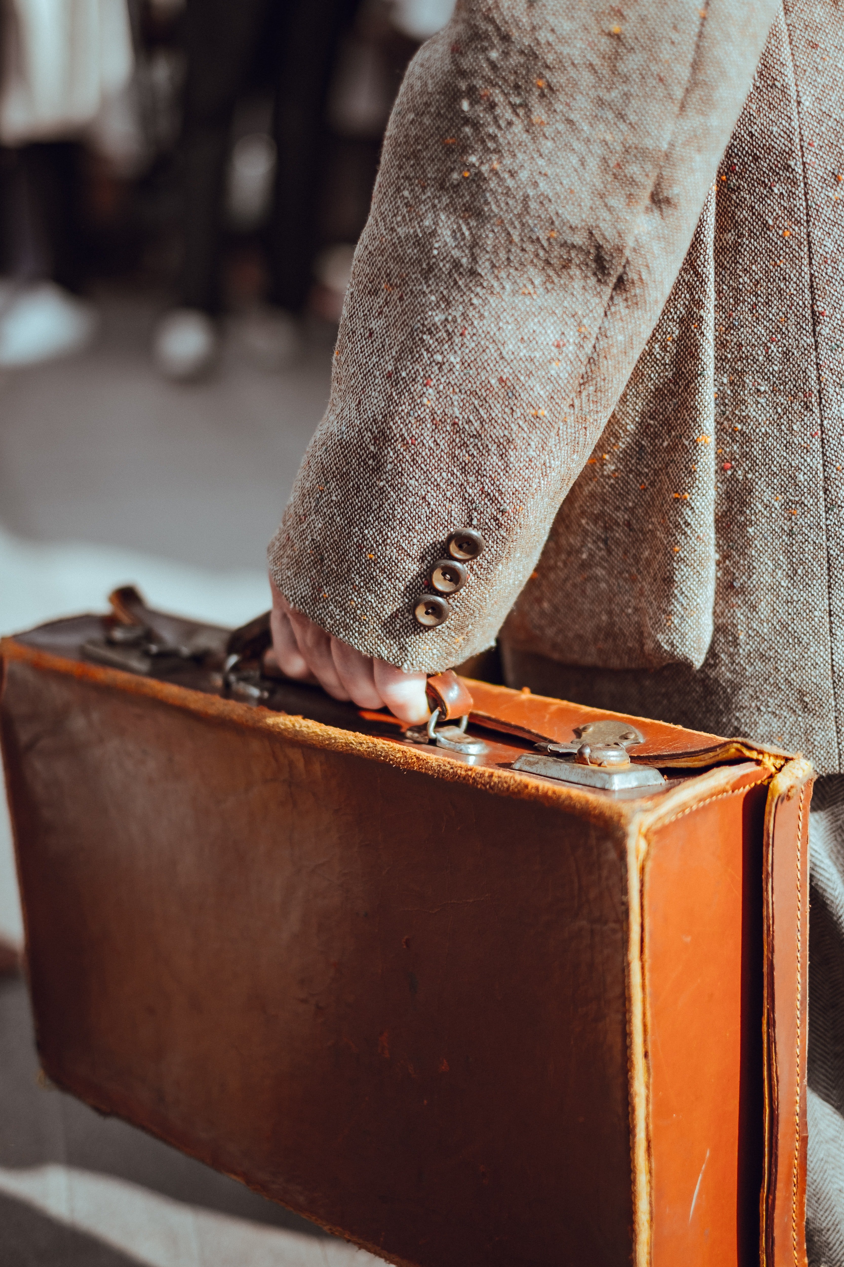 Una persona sosteniendo una maleta desgastada. | Foto: Unsplash