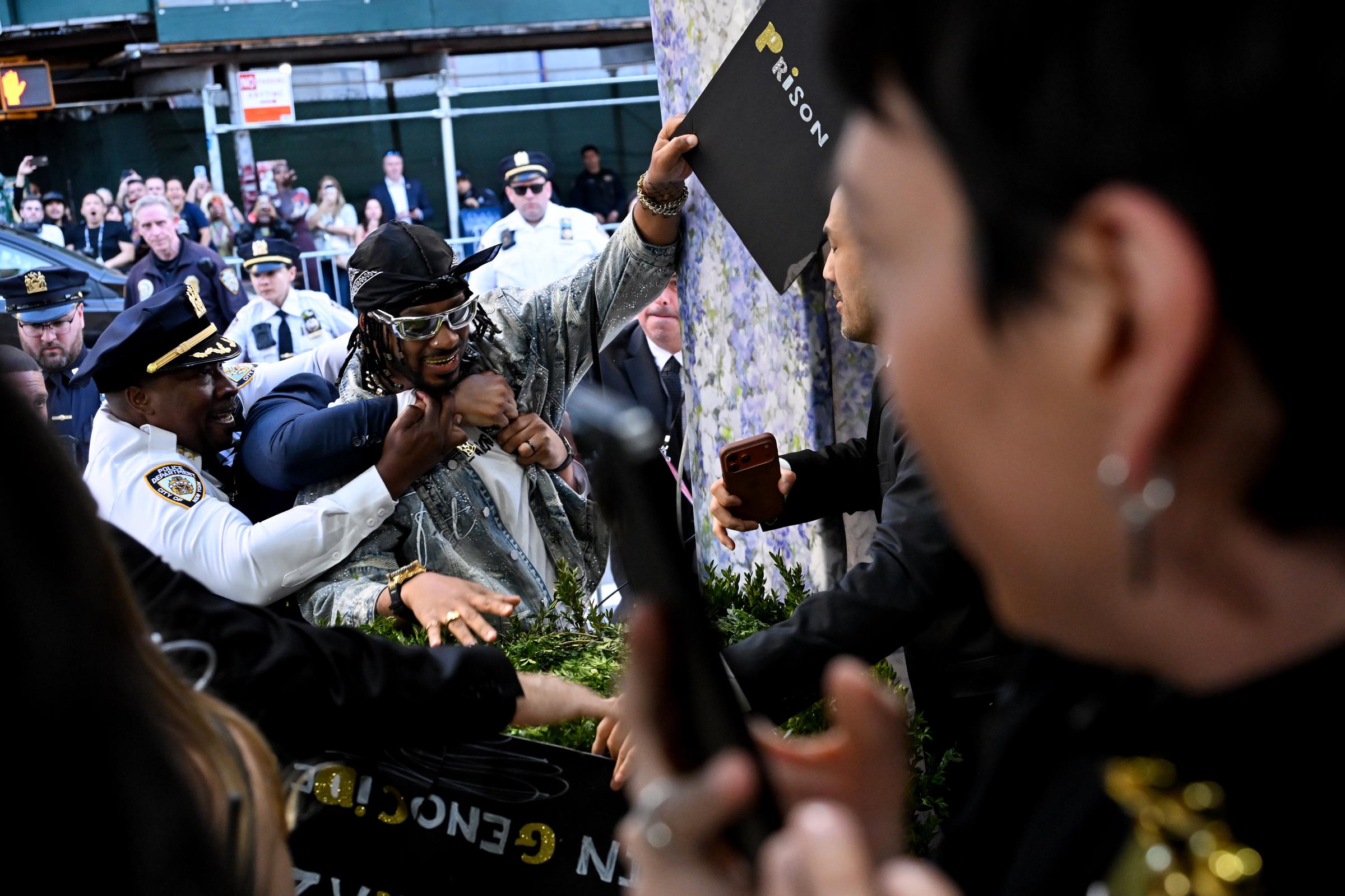 A member of the City of New York Police Department detains a protestor at the 2026 Met Gala | Source: Getty Images