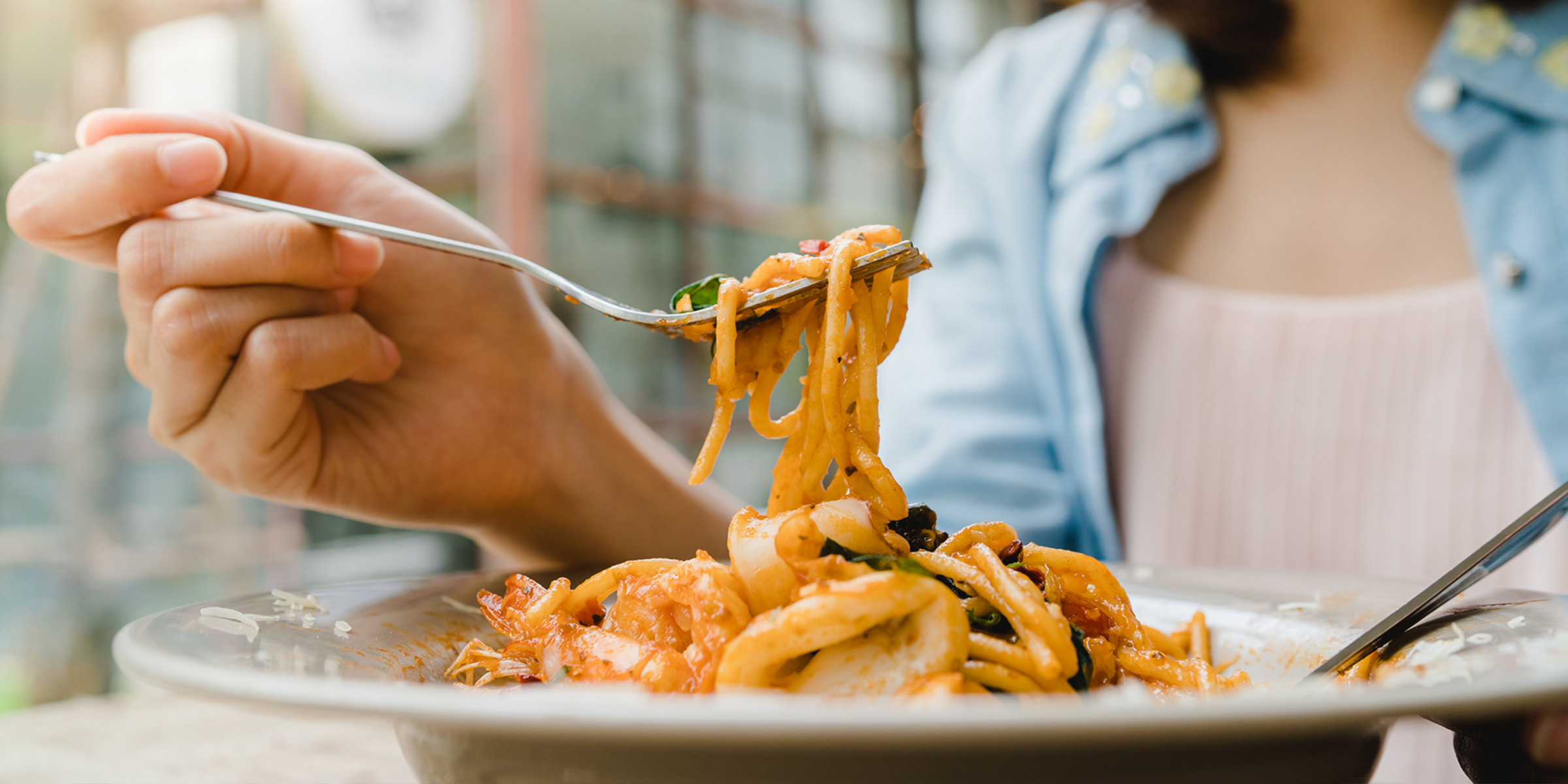 A closeup of a woman eating pasta | Source: Shutterstock