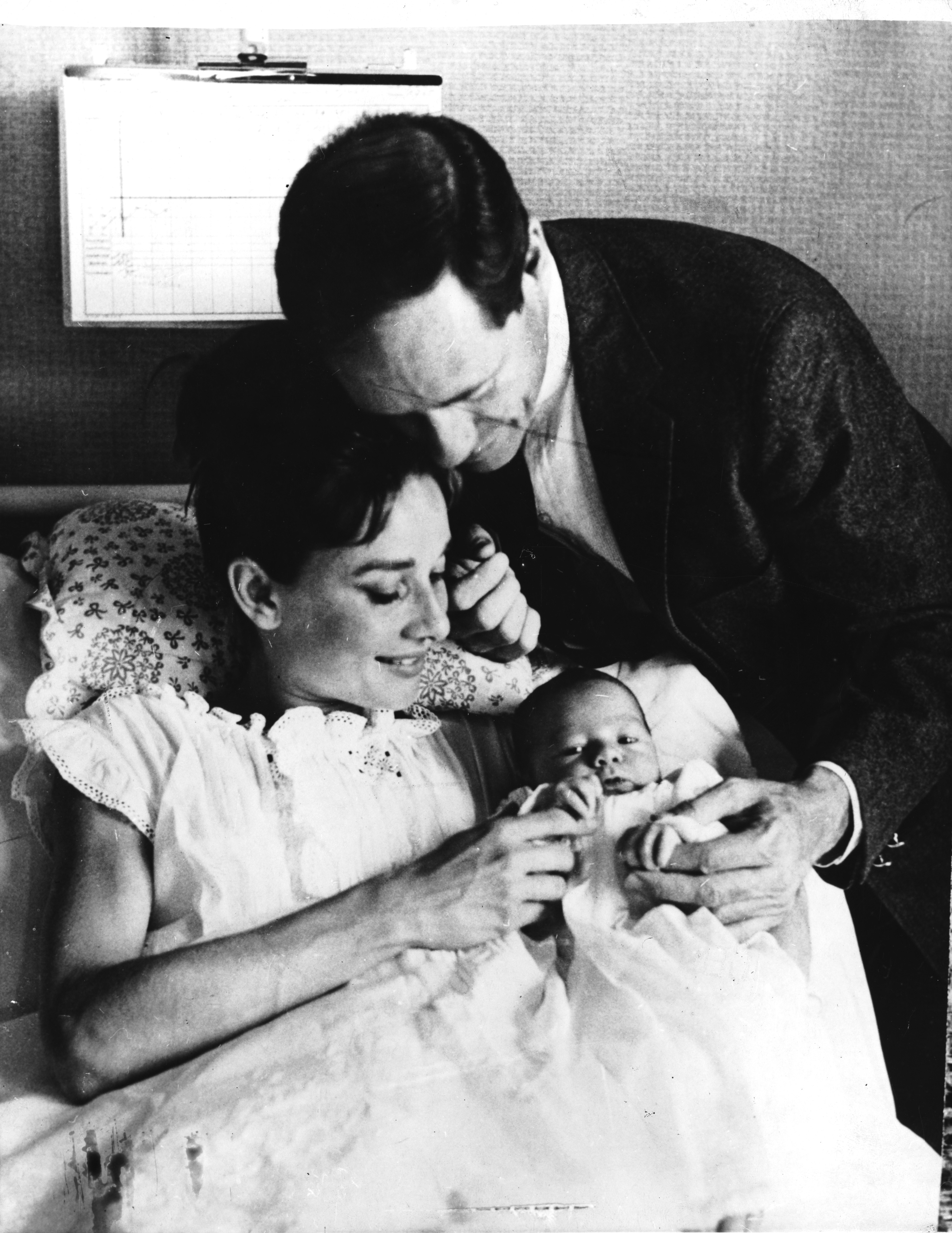 In this timeless black-and-white portrait, Audrey Hepburn gently holds her newborn son, Sean, just three days after his birth.