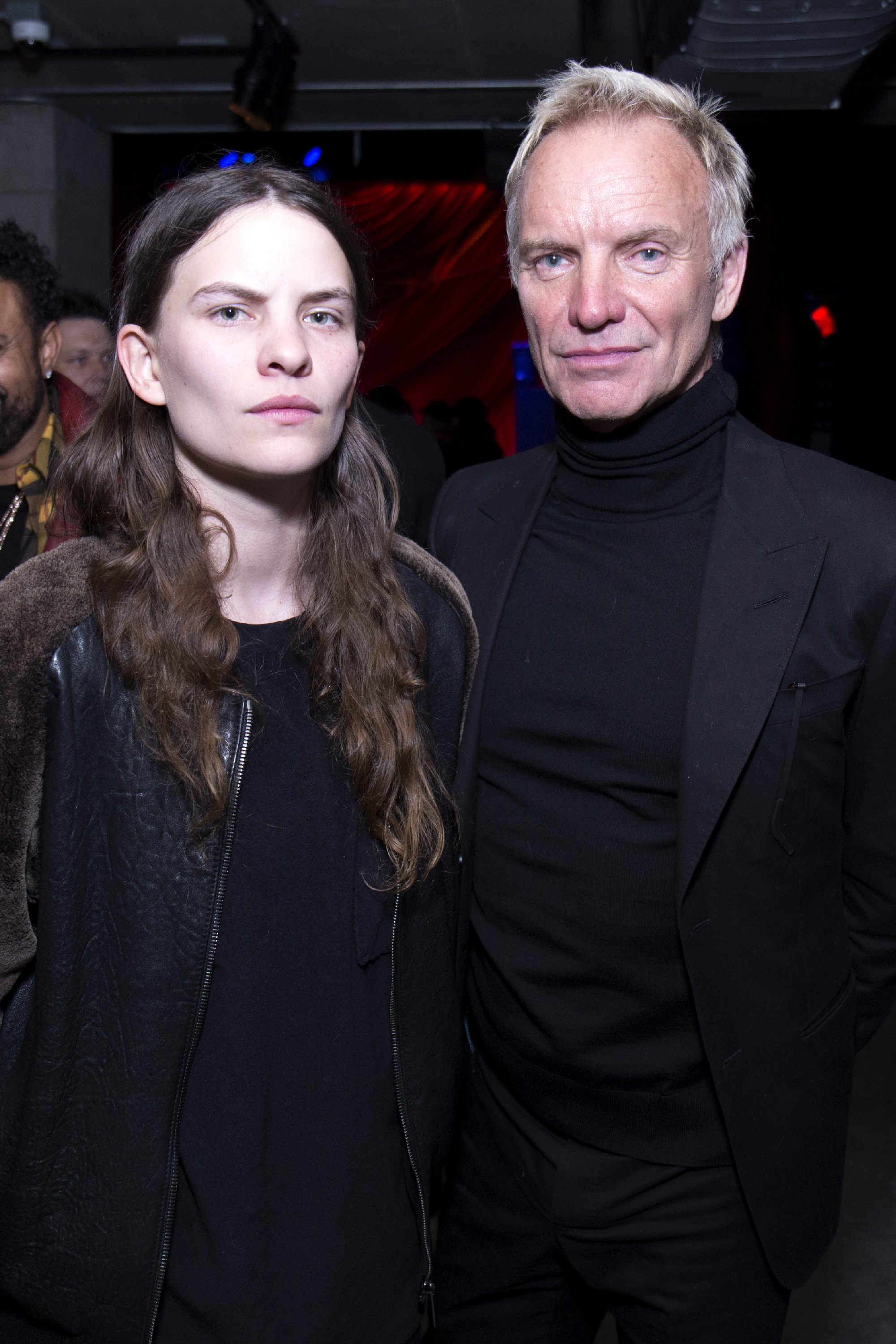 Eliot and Sting at the "Freak Show" premiere afterparty in New York, January 2018 — both in all-black, Eliot in a leather jacket and Sting in a turtleneck and blazer, their matching sharp bone structure visible even in the moody club lighting.