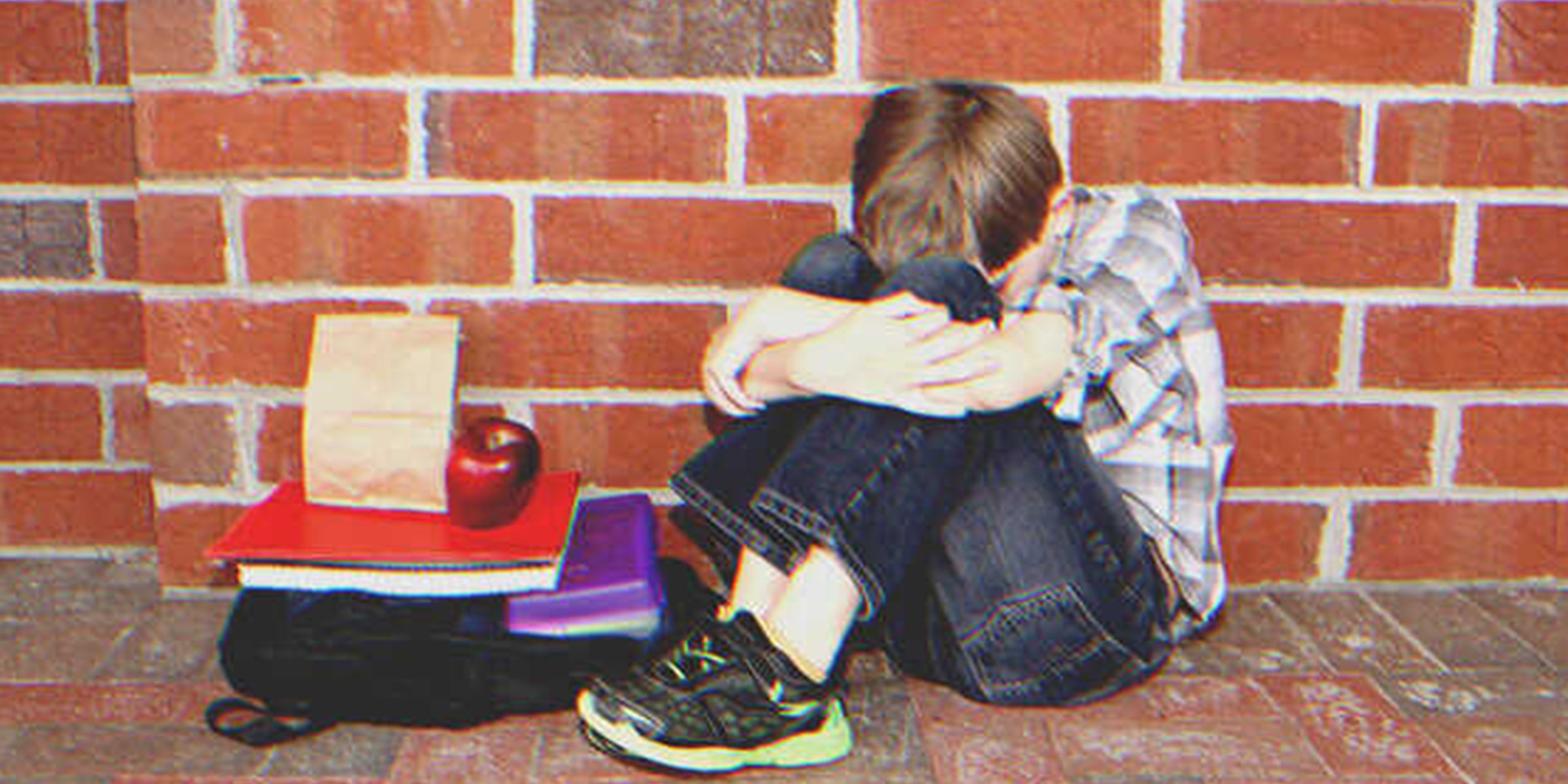 A sad kid sitting on the floor next to his lunch | Source: Shutterstock
