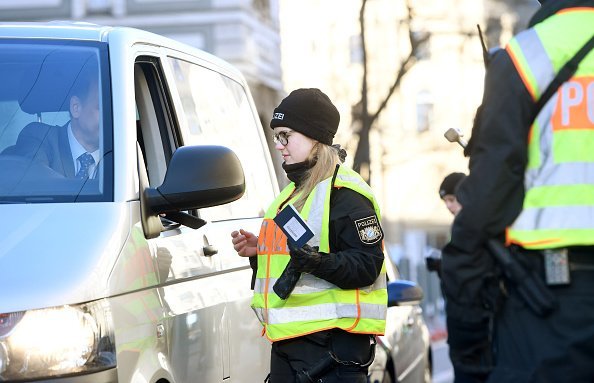 A policewoman checks a driver at a roadblock in Munich | Photo: Getty Images