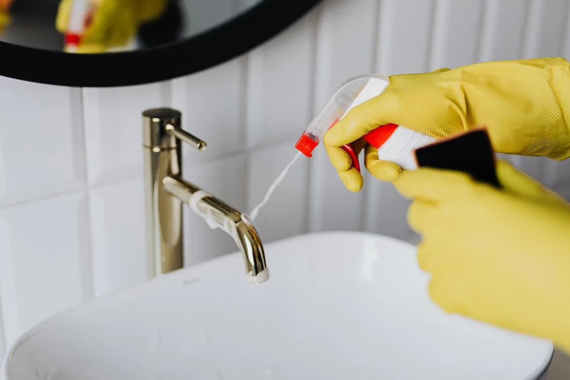 Alguien aplica limpiador en un lavamanos. | Foto: Pexels