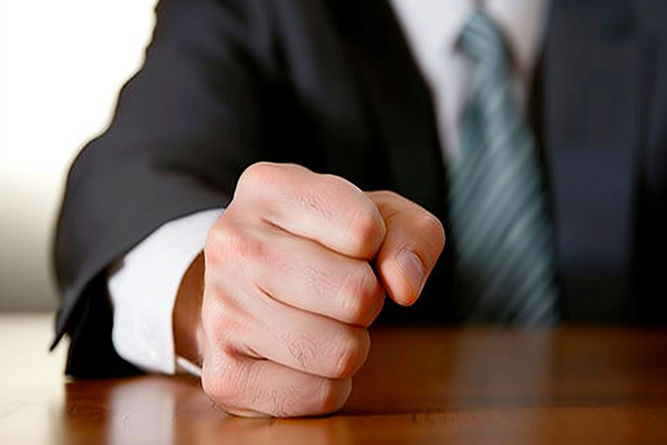 A close-up shot of a mans fist on a desk | Source: Midjourney