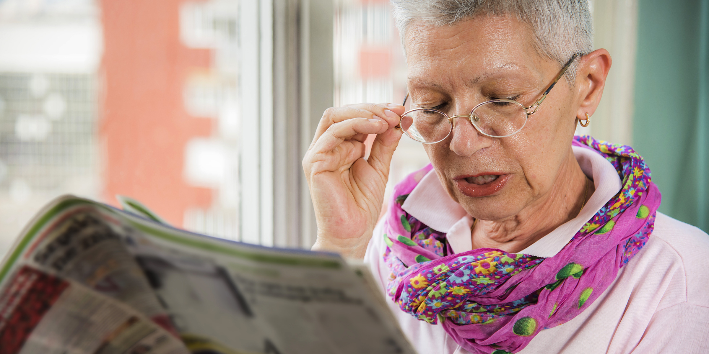 An elderly woman with a magazine | Source: Shutterstock