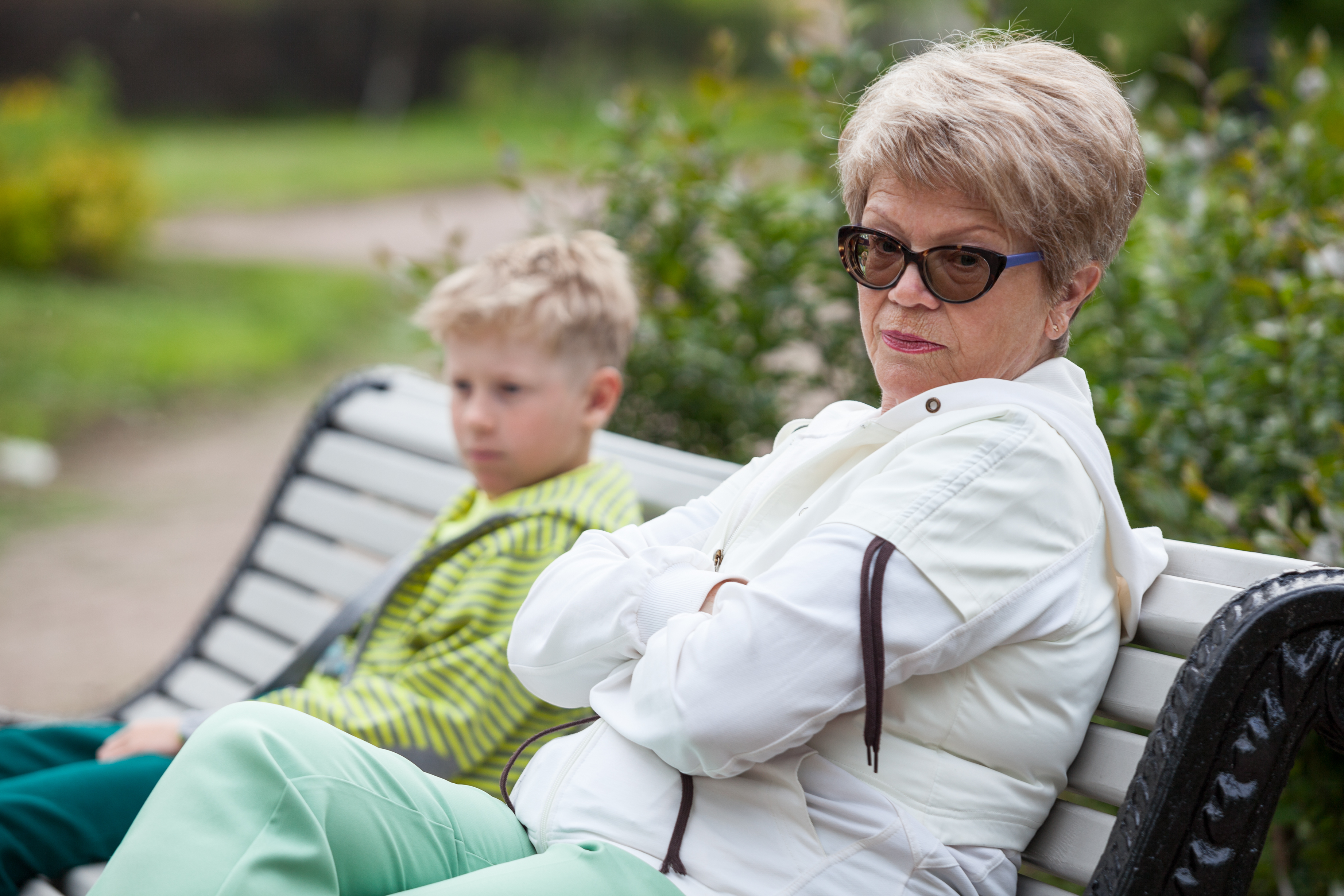 Older woman ignoring a young boy on a bench | Source: Shutterstock