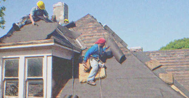 Two men fixing the roof of a house | Source: Shutterstock