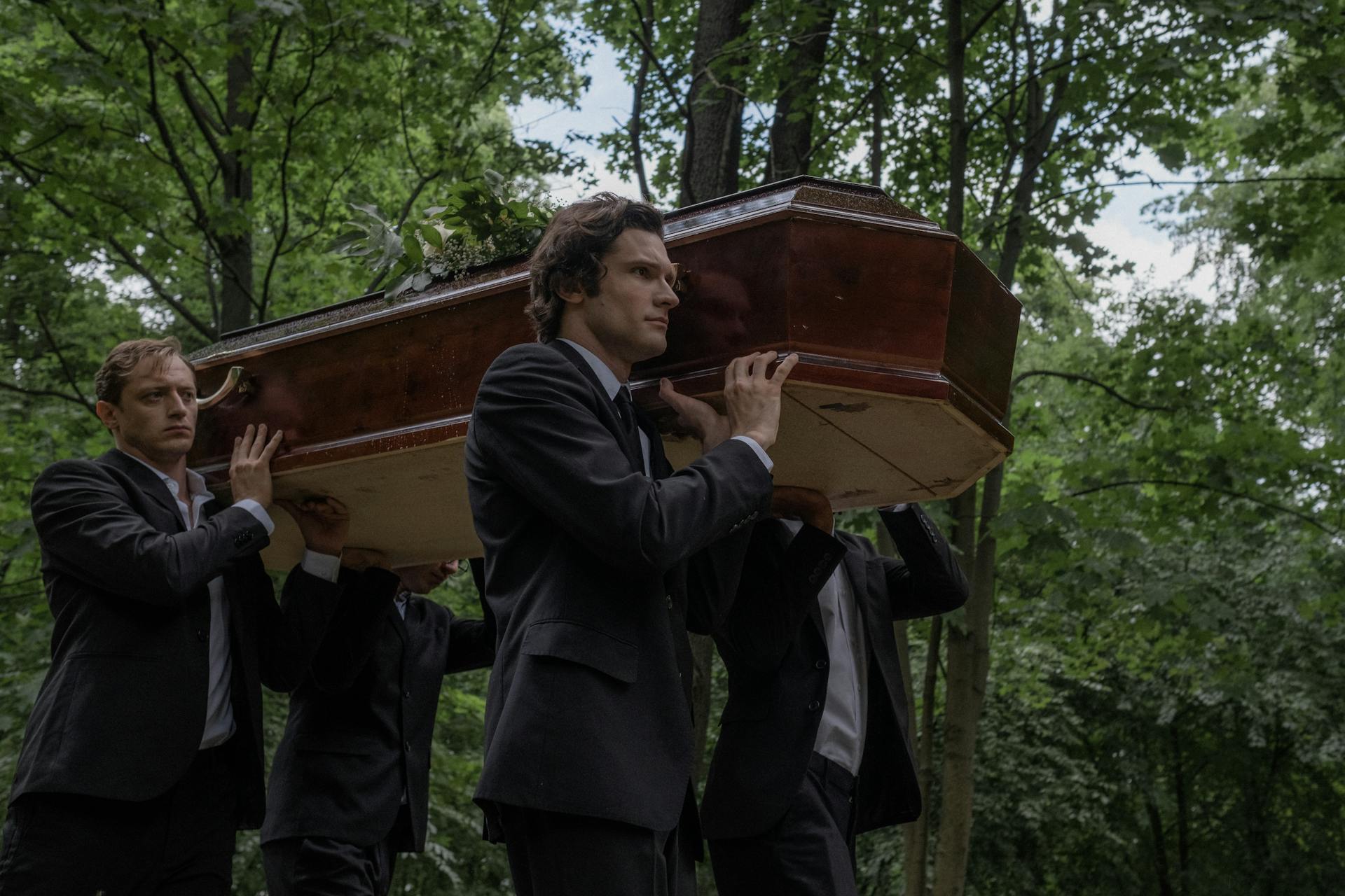 Men in dark suits carrying a coffin | Source: Pexels