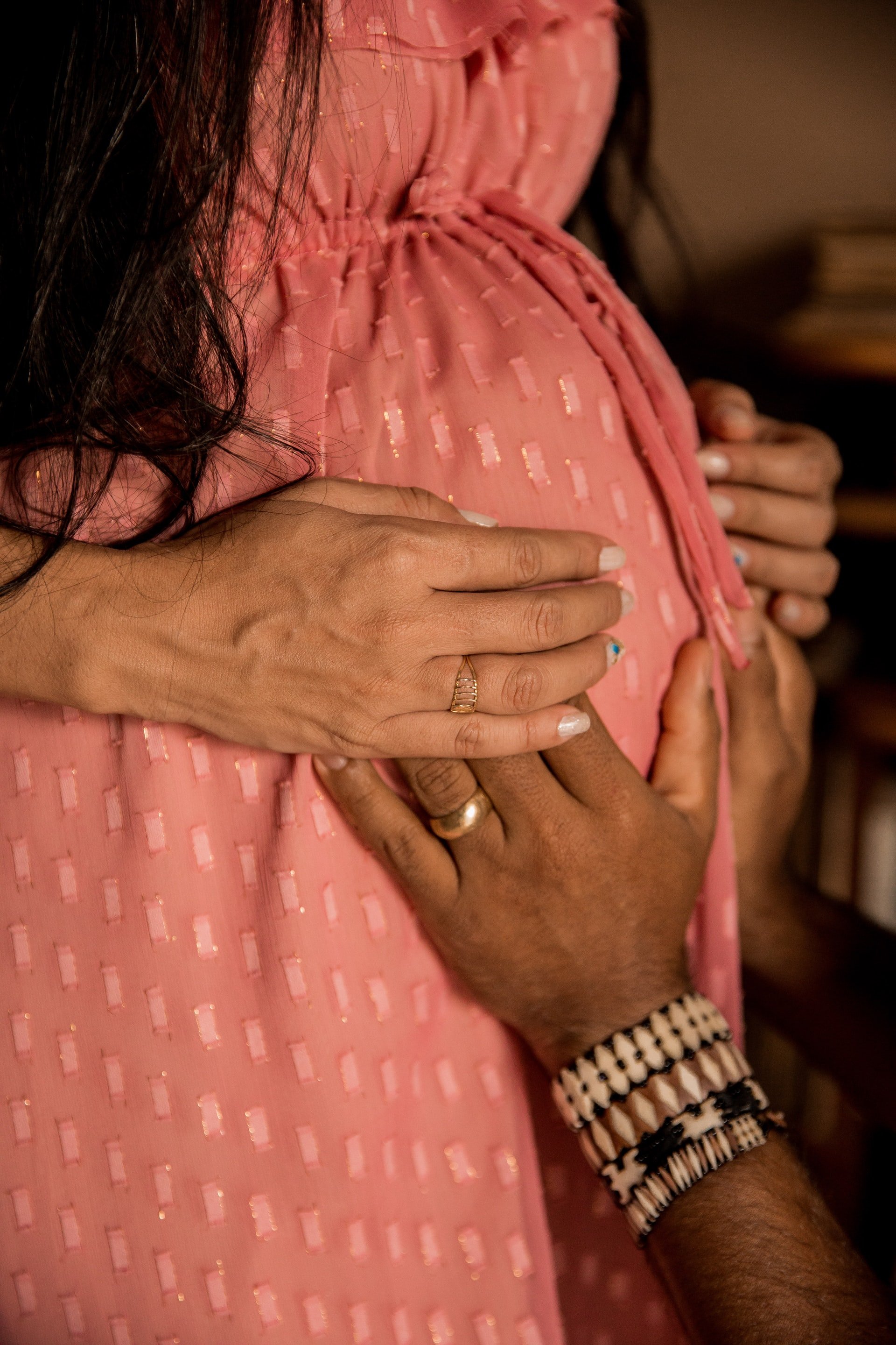 Person touching woman's baby bump | Source: Unsplash