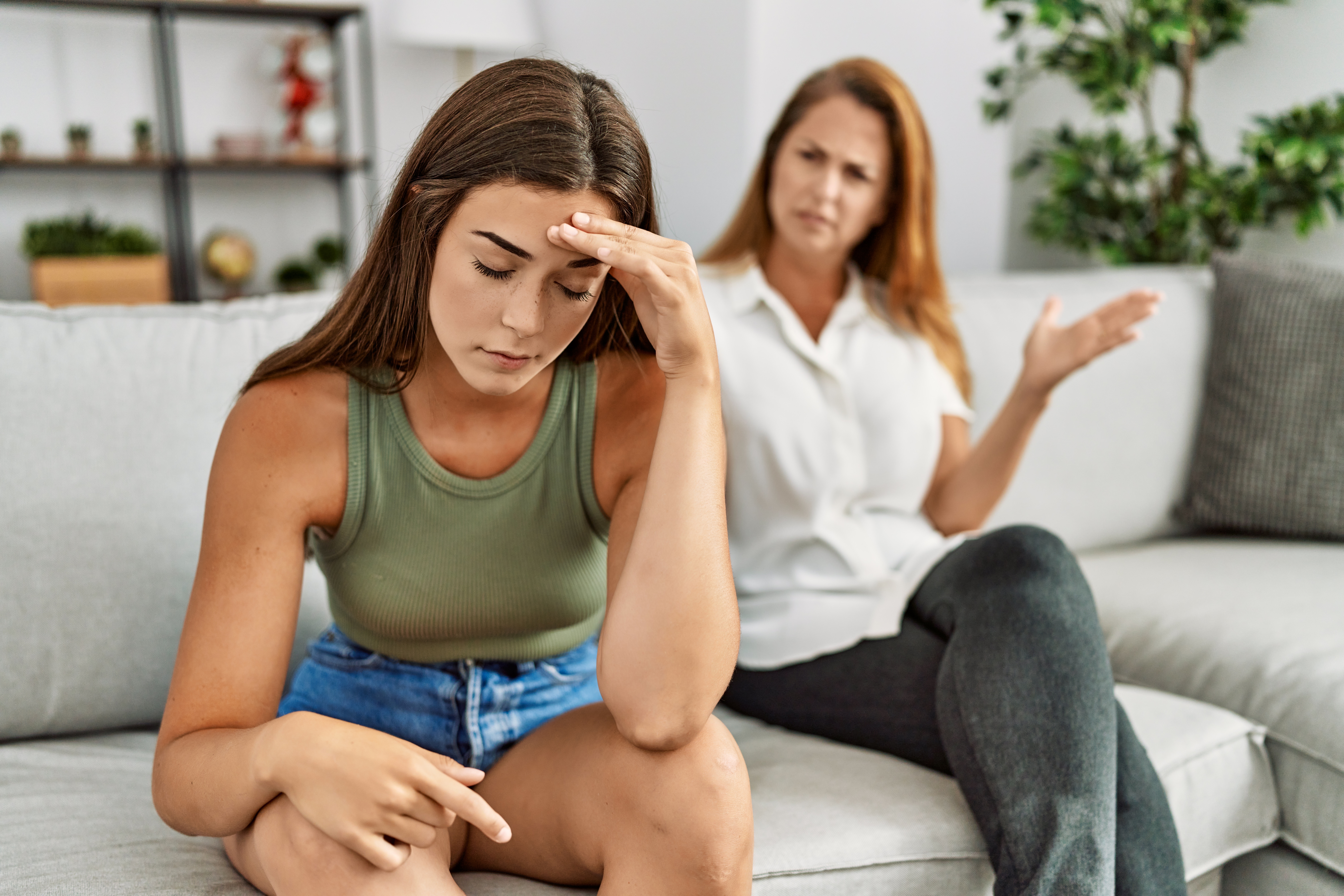 A young woman feeling tired during an argument with her mom | Source: Shutterstock