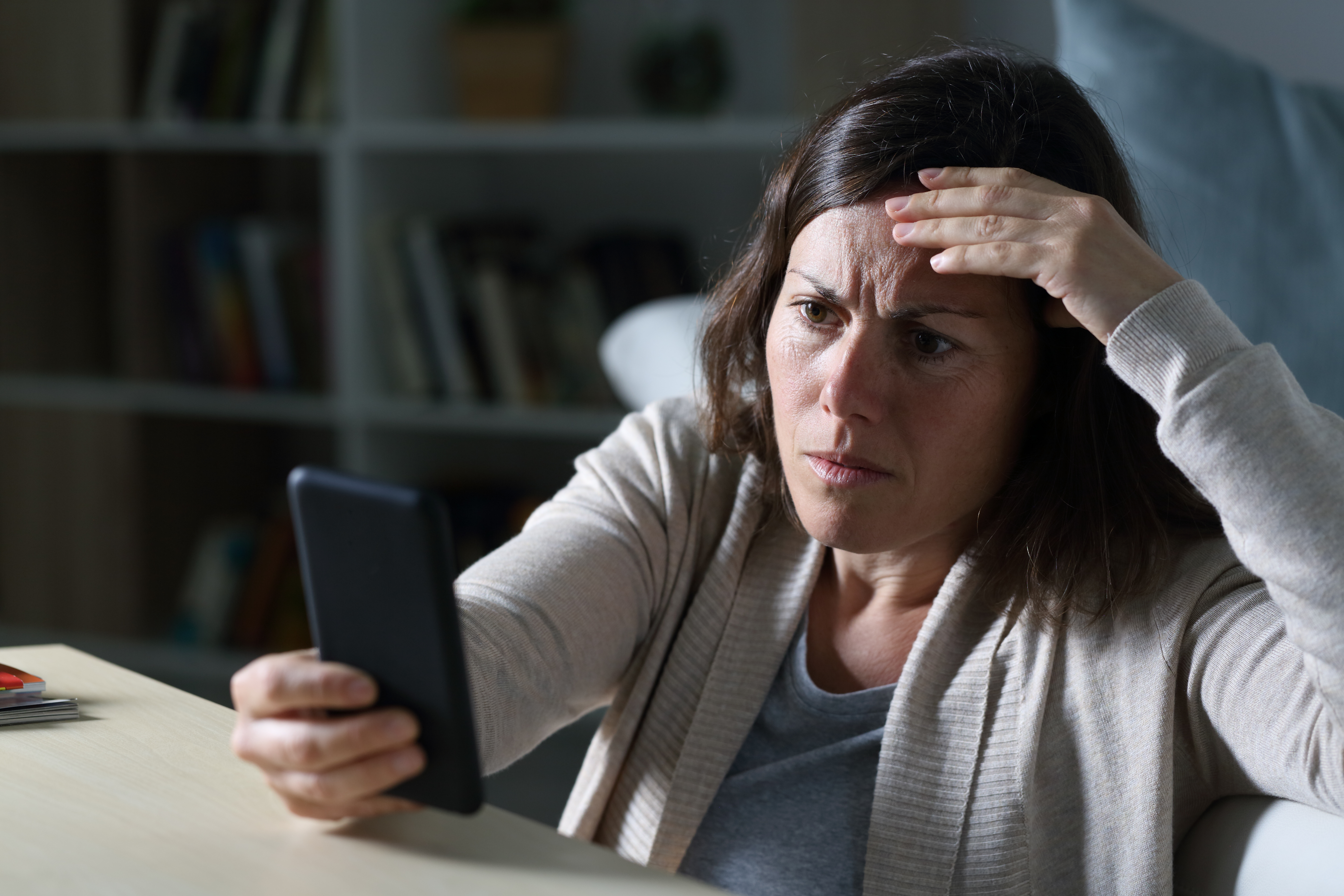 A woman looking worried while starring at a phone | Source: Shutterstock