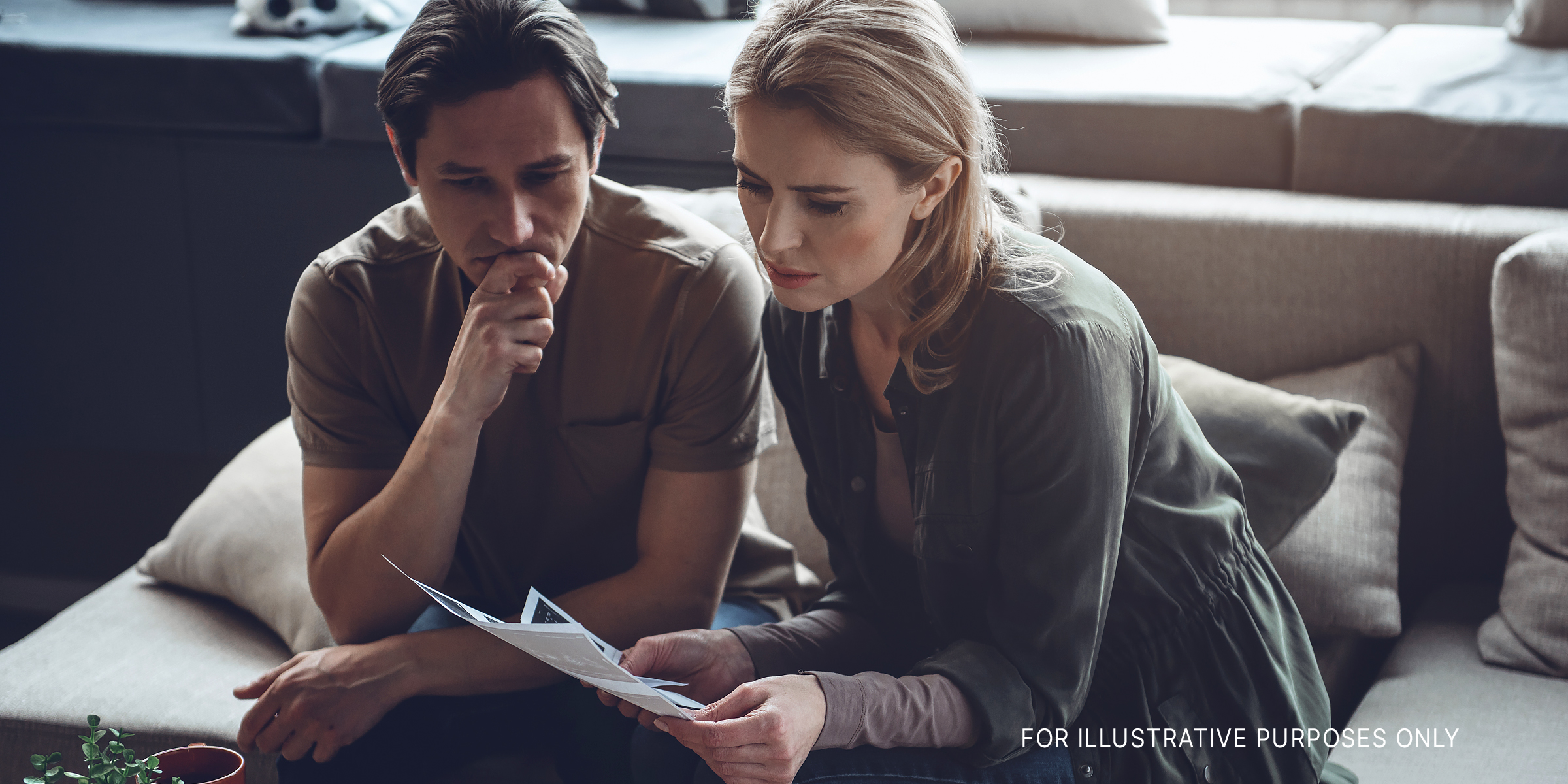 Depressed couple looking at a document | Source: Shutterstock