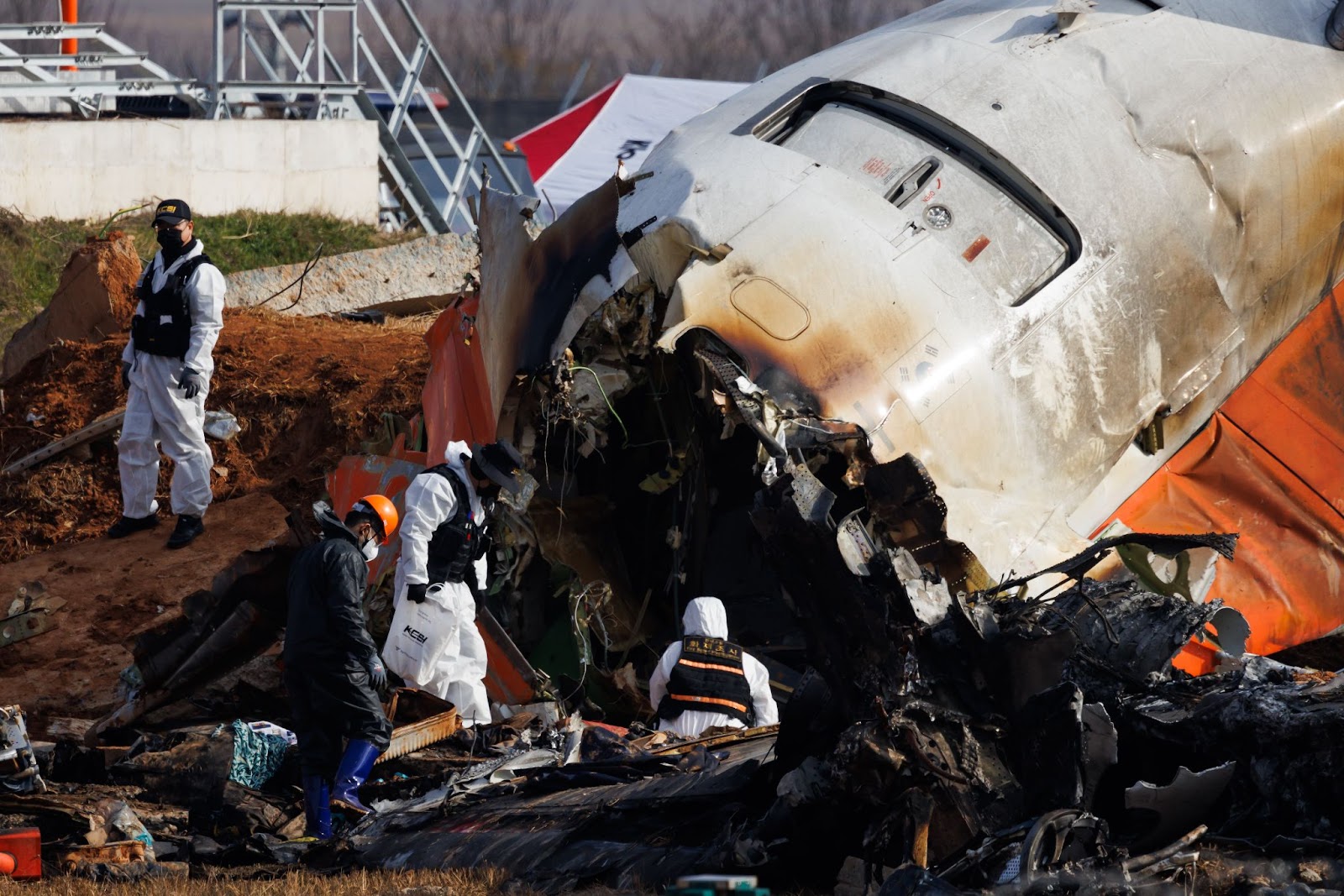 Forensic investigators inspecting the wreckage of Jeju Air Co. Flight 2216 at Muan International Airport in Muan County, South Korea, on December 30, 2024. | Source: Getty Images