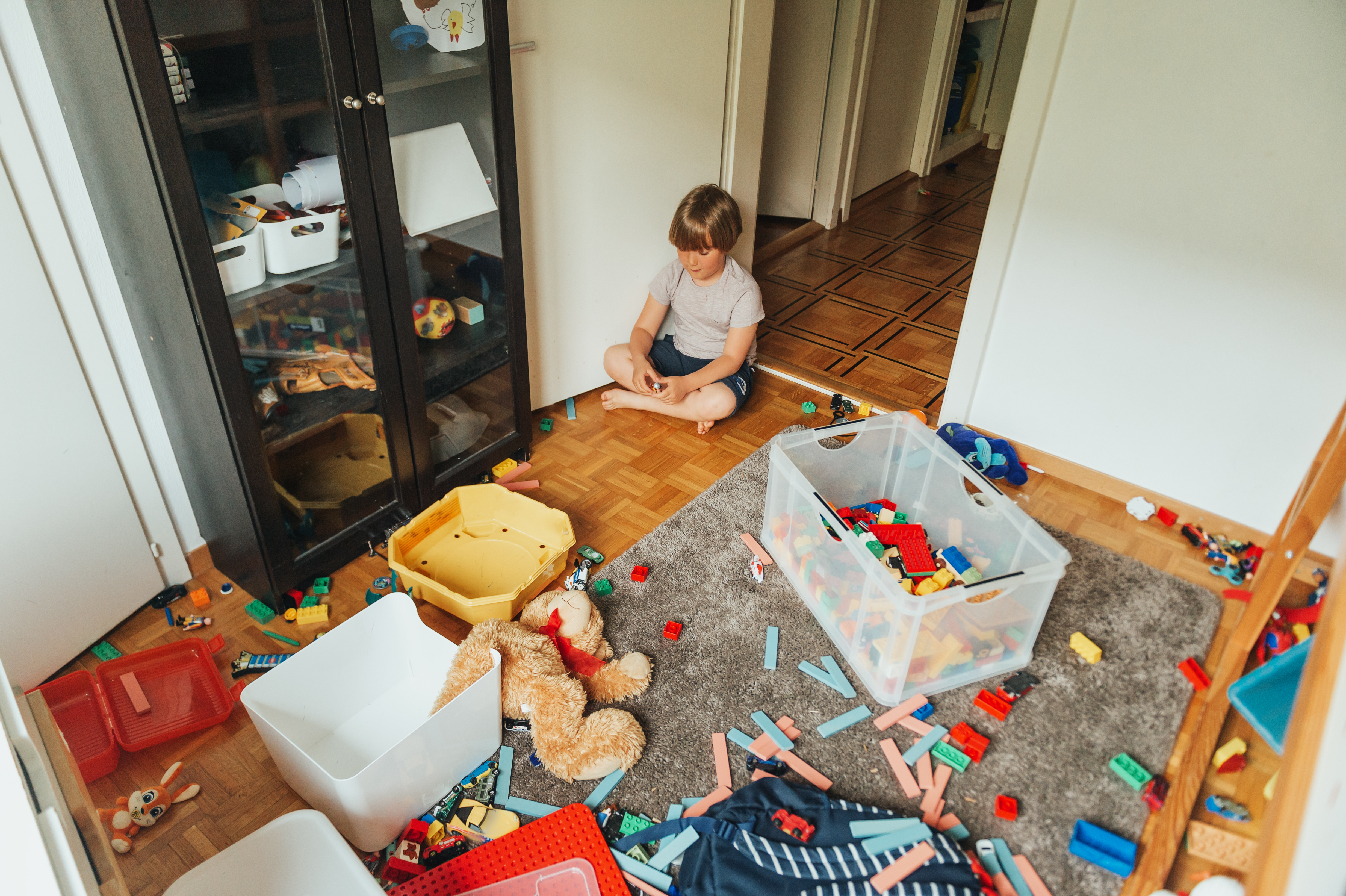 A child sitting in a messy room | Source: Shutterstock