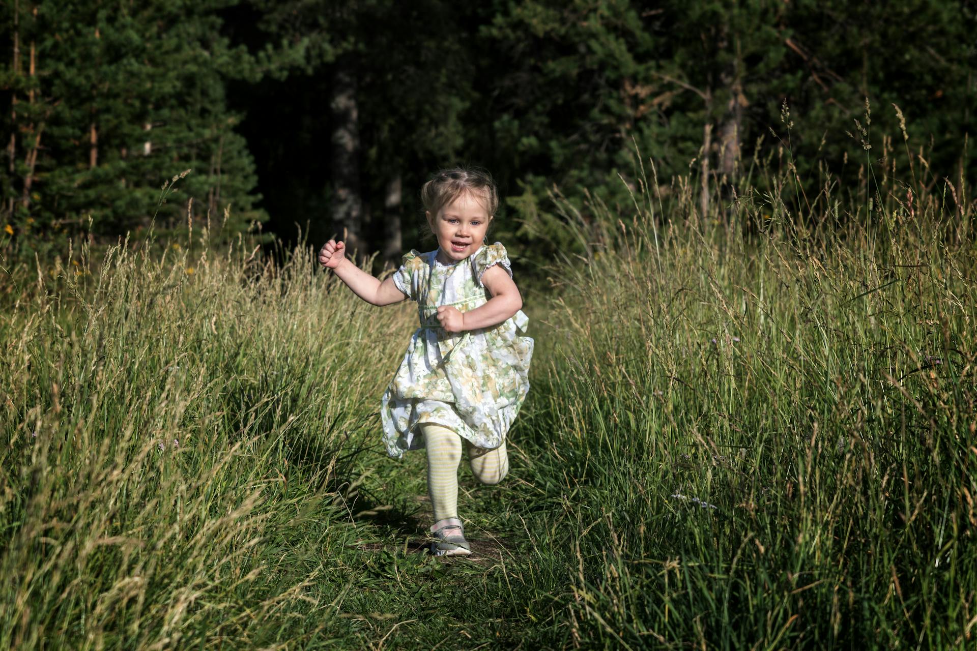 A little girl running on the grass | Source: Pexels