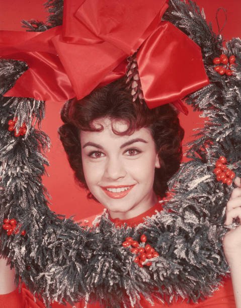 Annette Funicello, posing with her head encircled by a decorative Christmas wreath, circa 1955. | Source: Getty Images