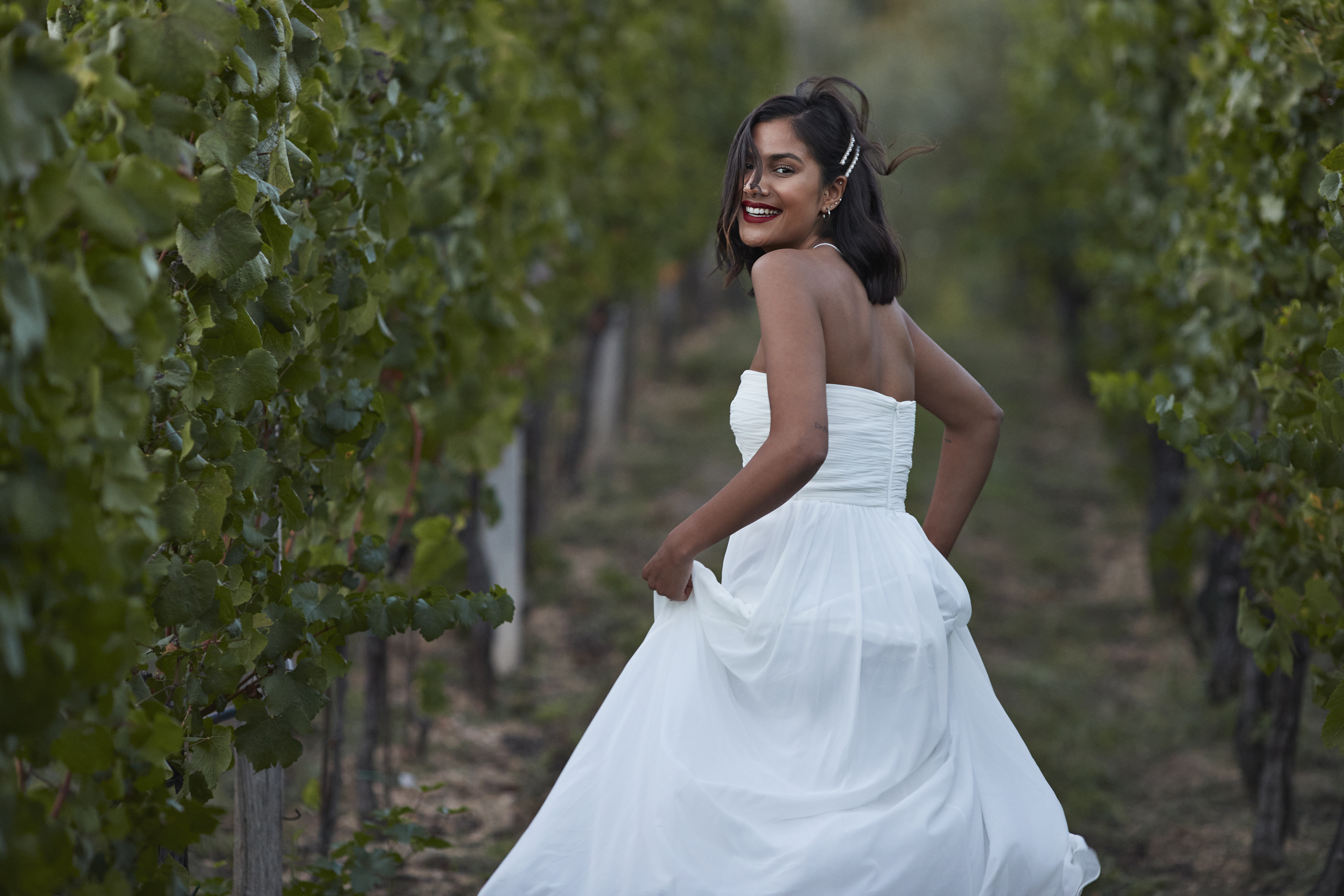 A woman in a field, smiling in her wedding dress | Source: Getty Images