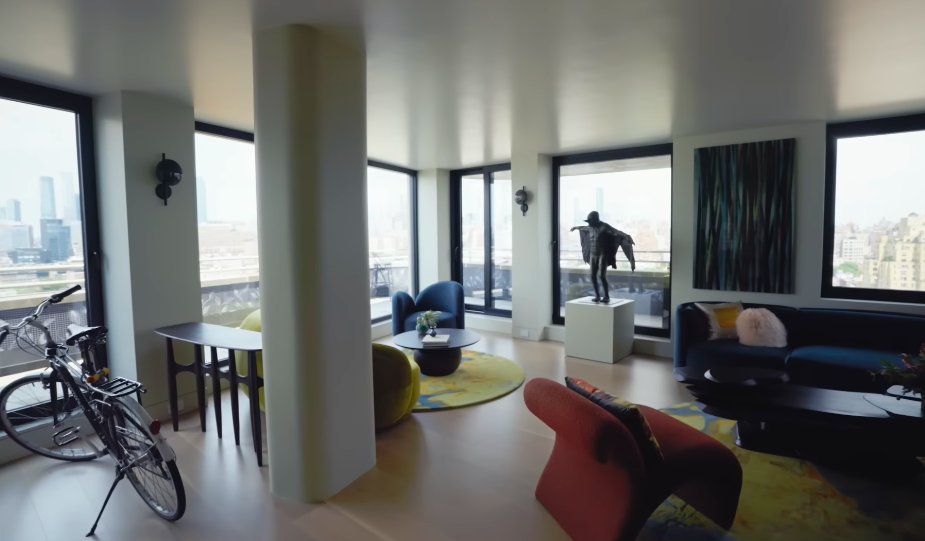 This imposing sculpture effectively gets its own stage — with Manhattan providing the backdrop. Its position beside the glass turns the artwork into one of the first things visitors notice across the room. | Source: YouTube/Architectural Digest