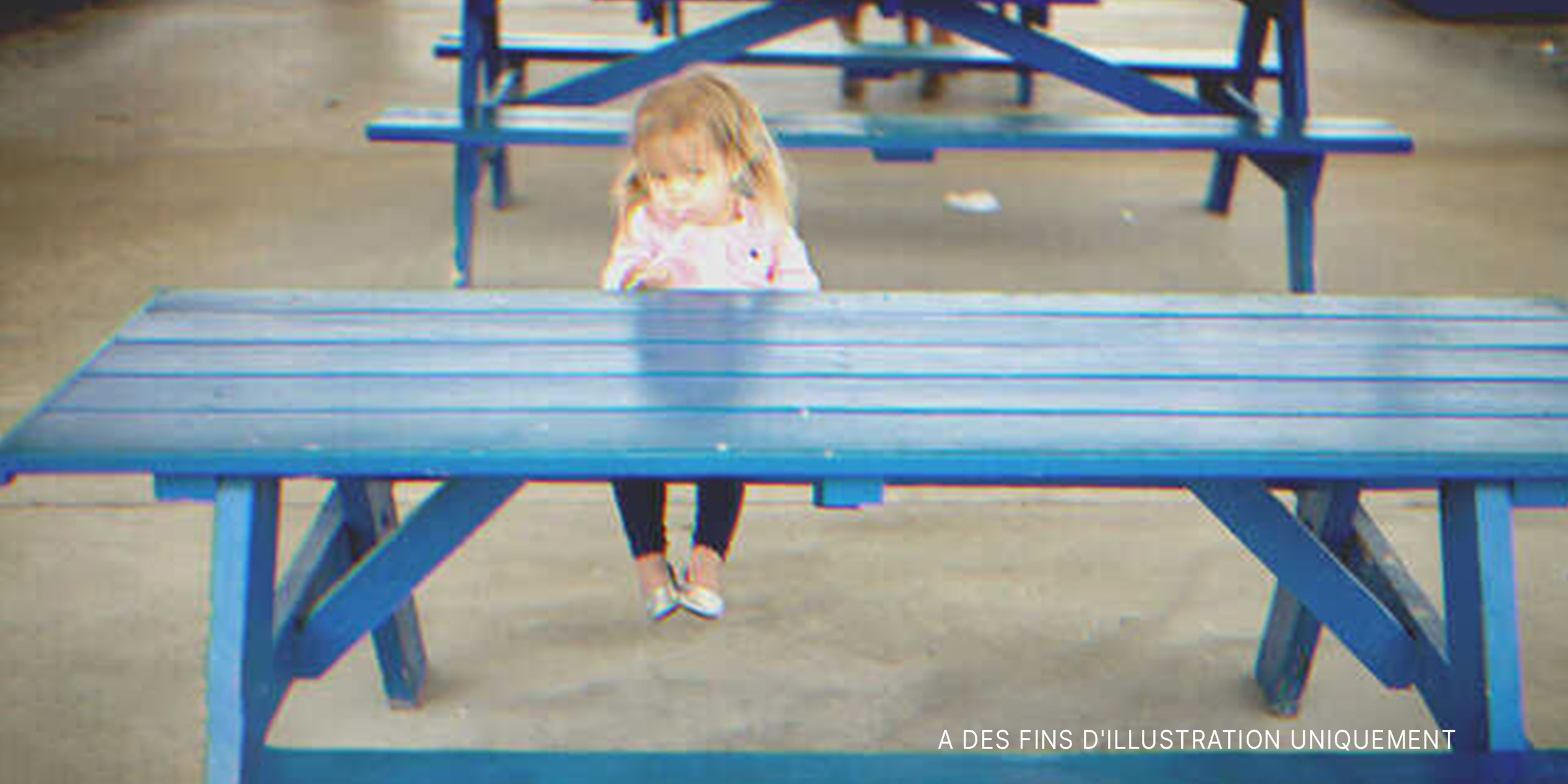 Une petite fille solitaire assise sur un banc | Source : Shutterstock