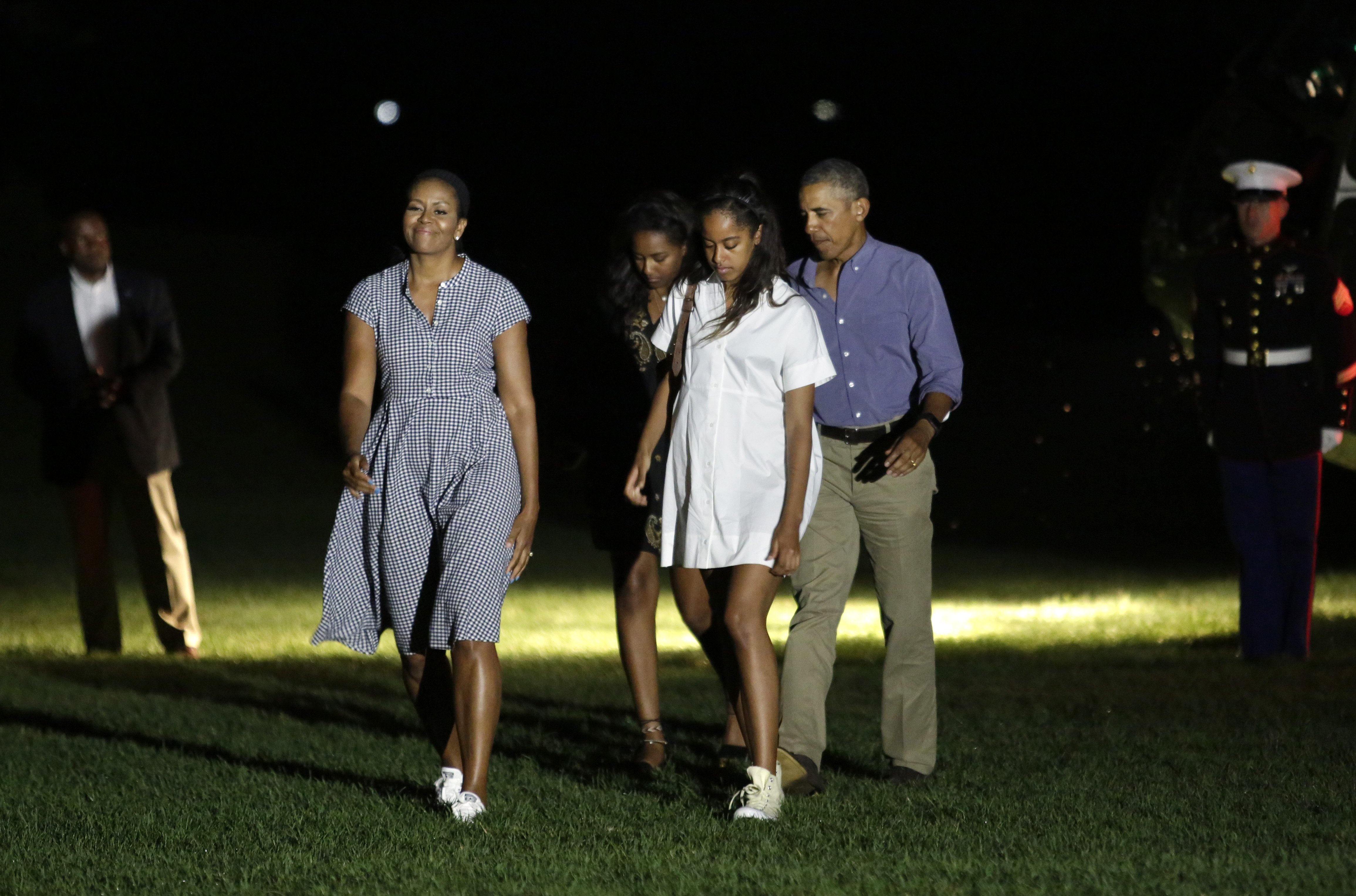 Barack Obama waves as he walks with First lady Michelle Obama and their daughters Malia and Sasha on the South Lawn of the White House in Washington upon their return from a summer vacation in Martha's Vineyard, Massachusetts, on August 21, 2016. | Source: Getty Images