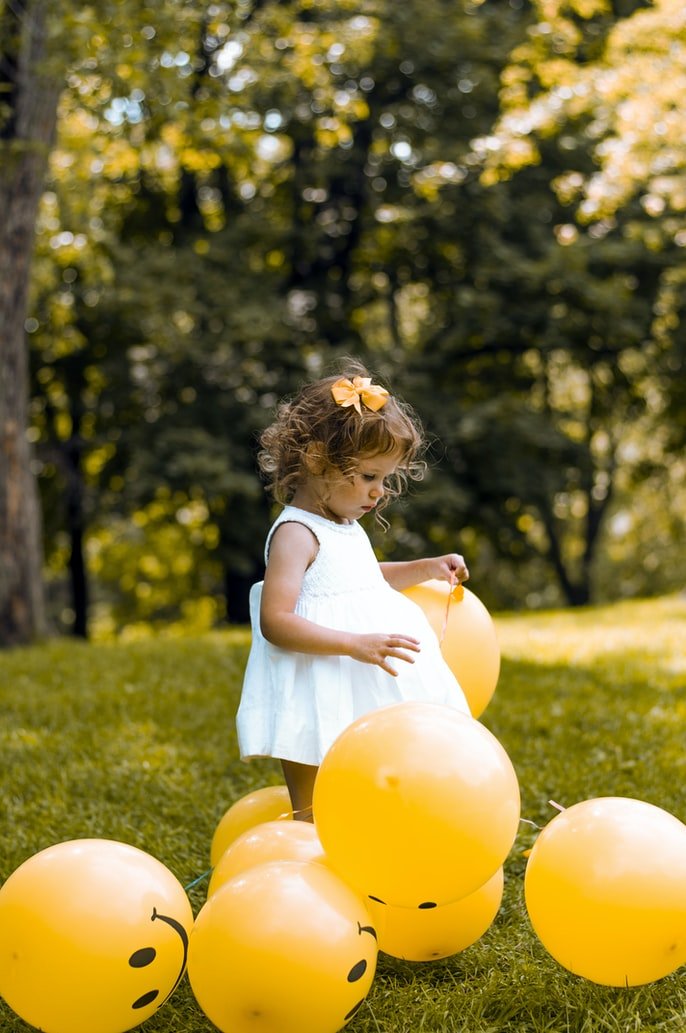Niña con globos en un parque. | Foto: Unsplash