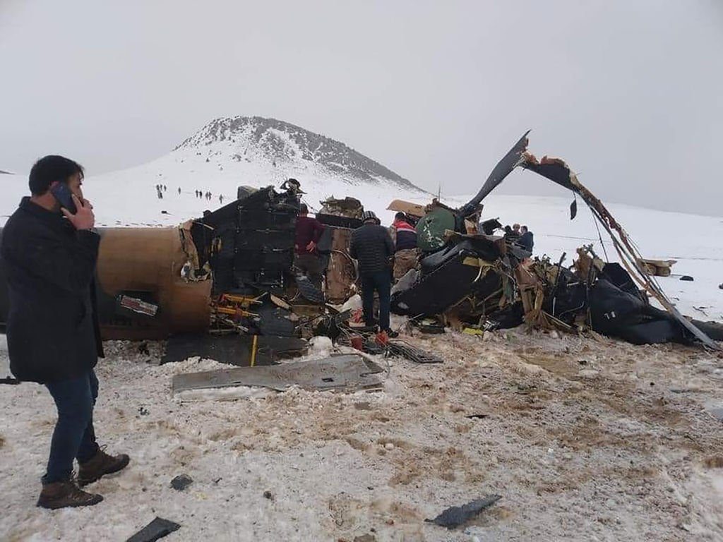 Rescue workers, soldiers and civilians walk around the wreckage of a military helicopter that crashed on March 4, 2021 | Photo: Getty Images