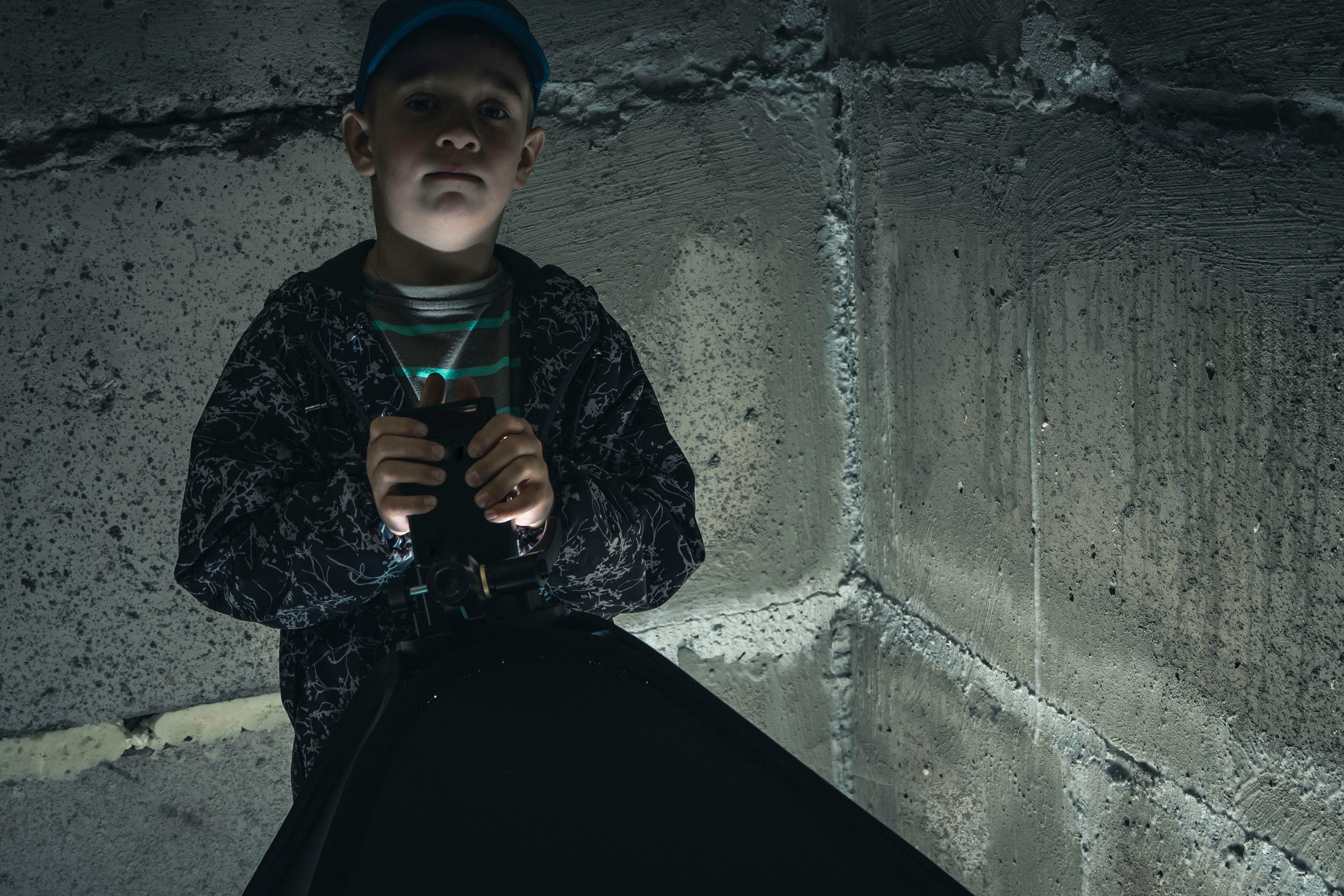 Boy in a dark concrete basement. | Source: Shutterstock