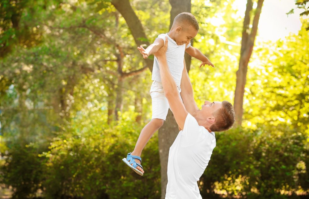 A young man playing with his adopted son. | Photo: Shutterstock
