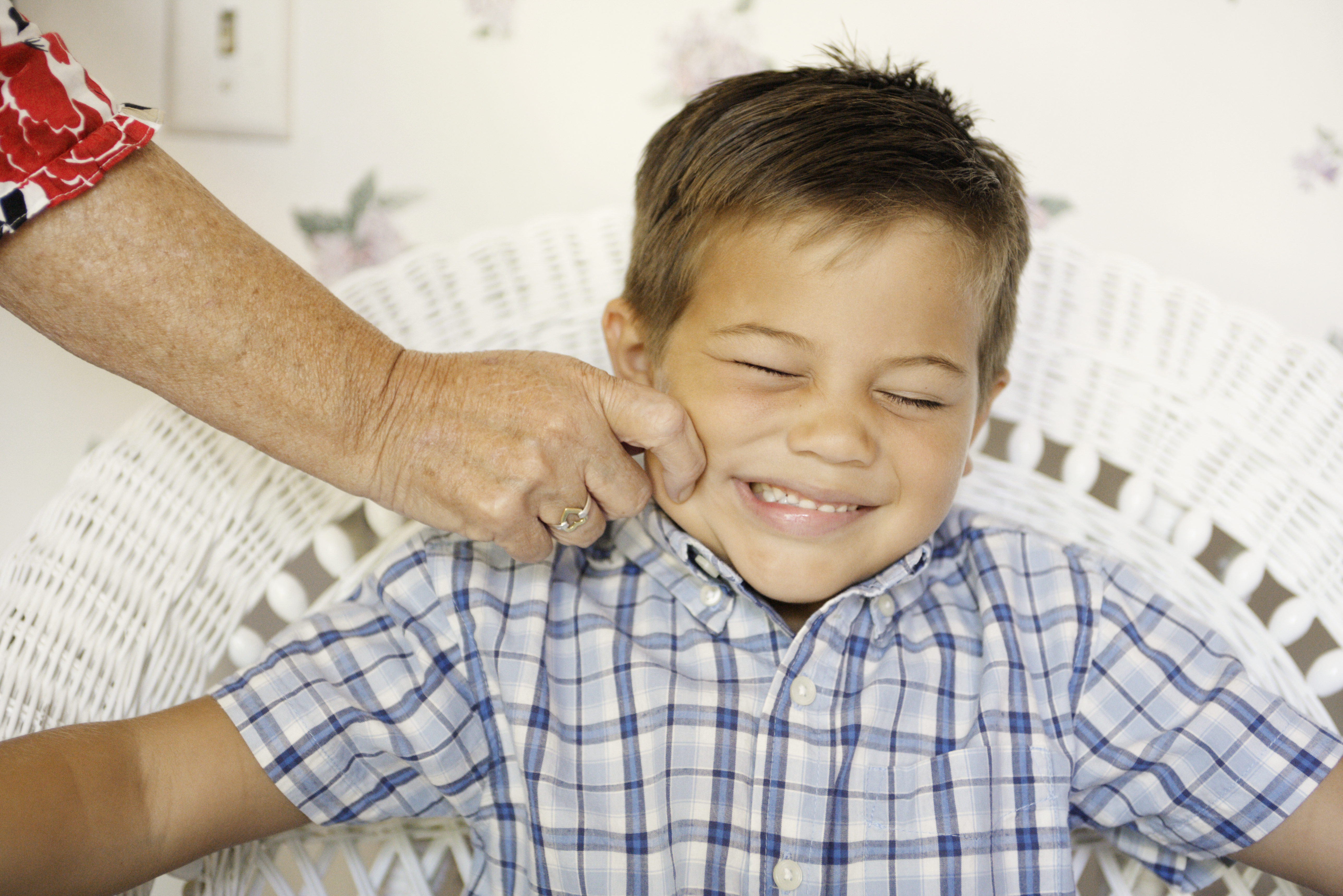 Senior Woman Pinching Boy's Cheek | Source: Getty Images