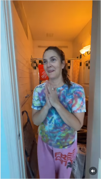 Drew Barrymore she’s clapping and smiling as she steps out of a bathroom filled with building supplies from a video posted on July 21, 2025 | Source: Instagram/drewbarrymore