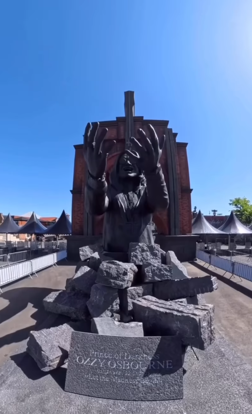 With his arms raised and face turned upward, Ozzy Osbourne's likeness appears to emerge from fractured stone in Philippe Pasqua's six-meter-tall tribute at Hellfest. | Source: Instagram/sharonosbourne