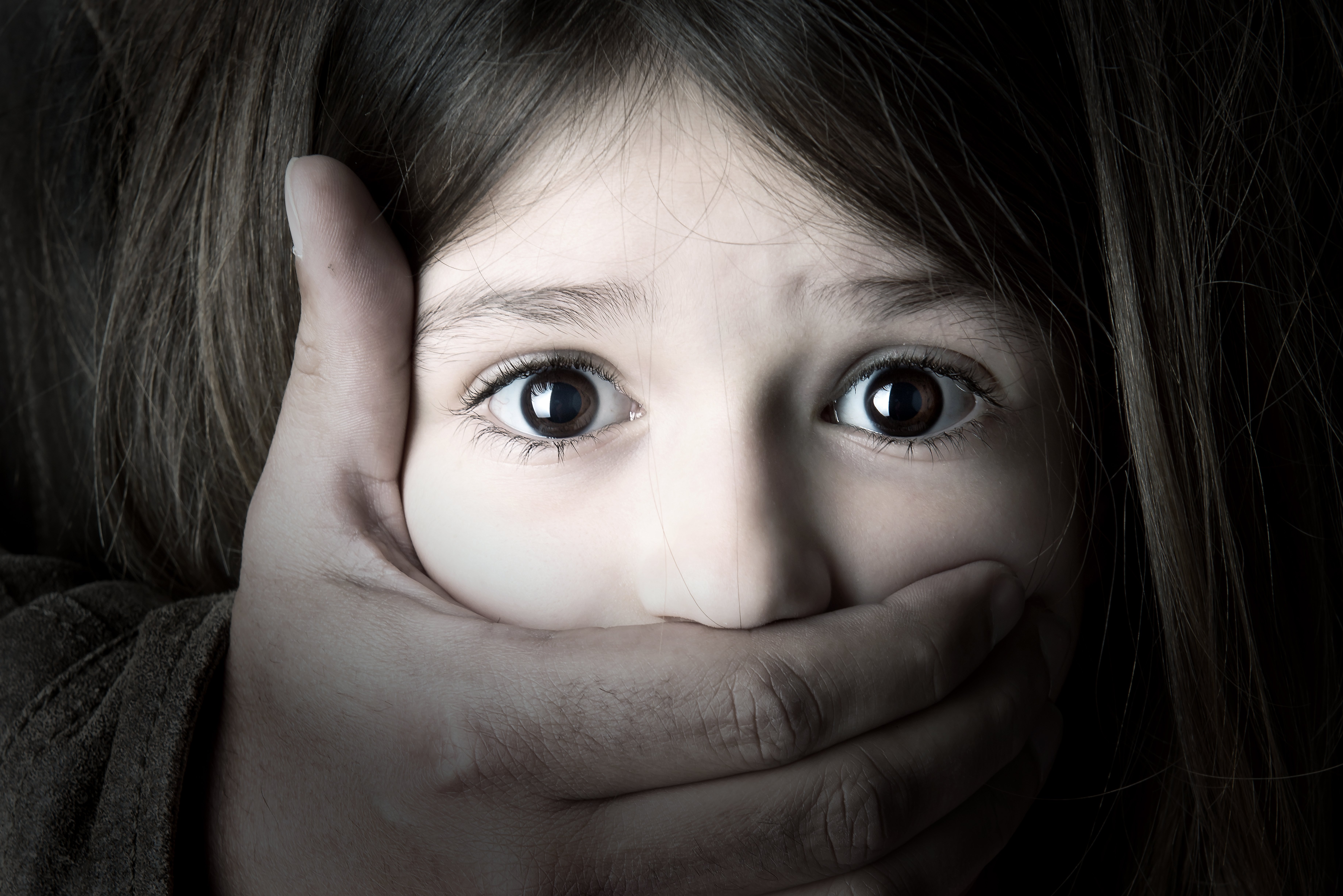 A una niña le tapan la boca con una mano. Fuente: Shutterstock A una niña le tapan la boca con una mano. Fuente: Shutterstock