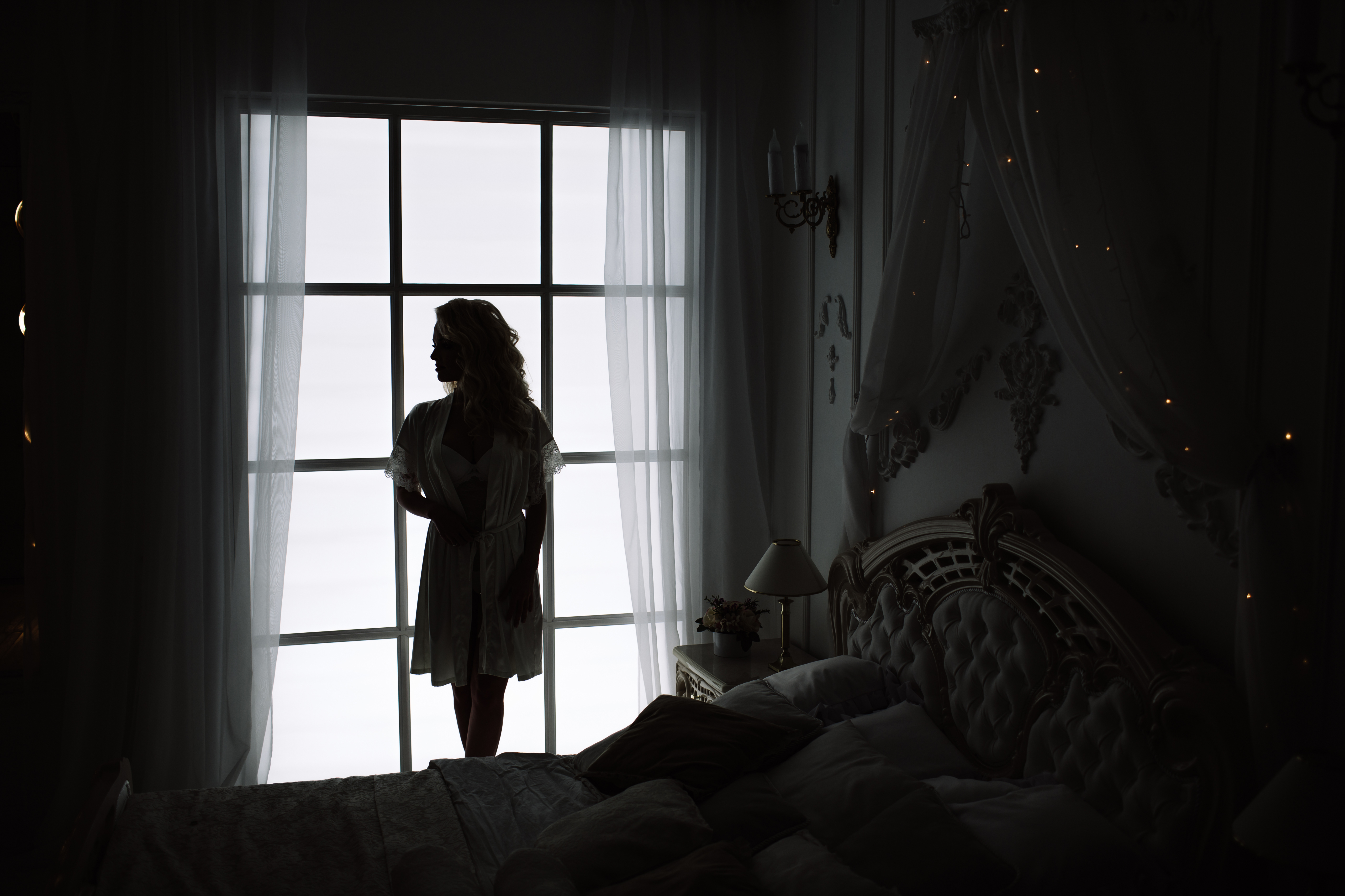 The silhouette of a woman by the window of a bedroom | Source: Shutterstock