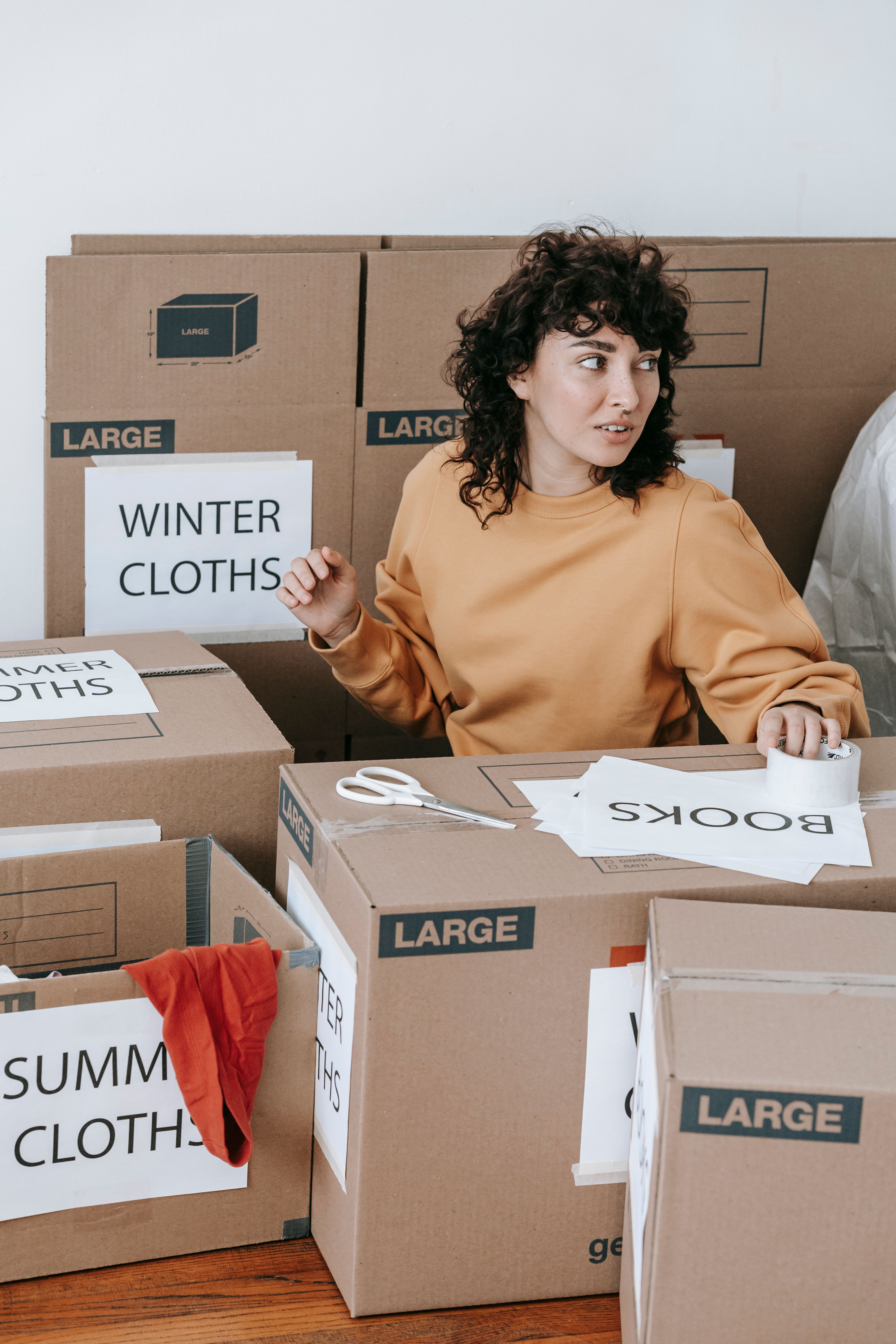 Woman storing things in labeled boxes | Source: Pexels