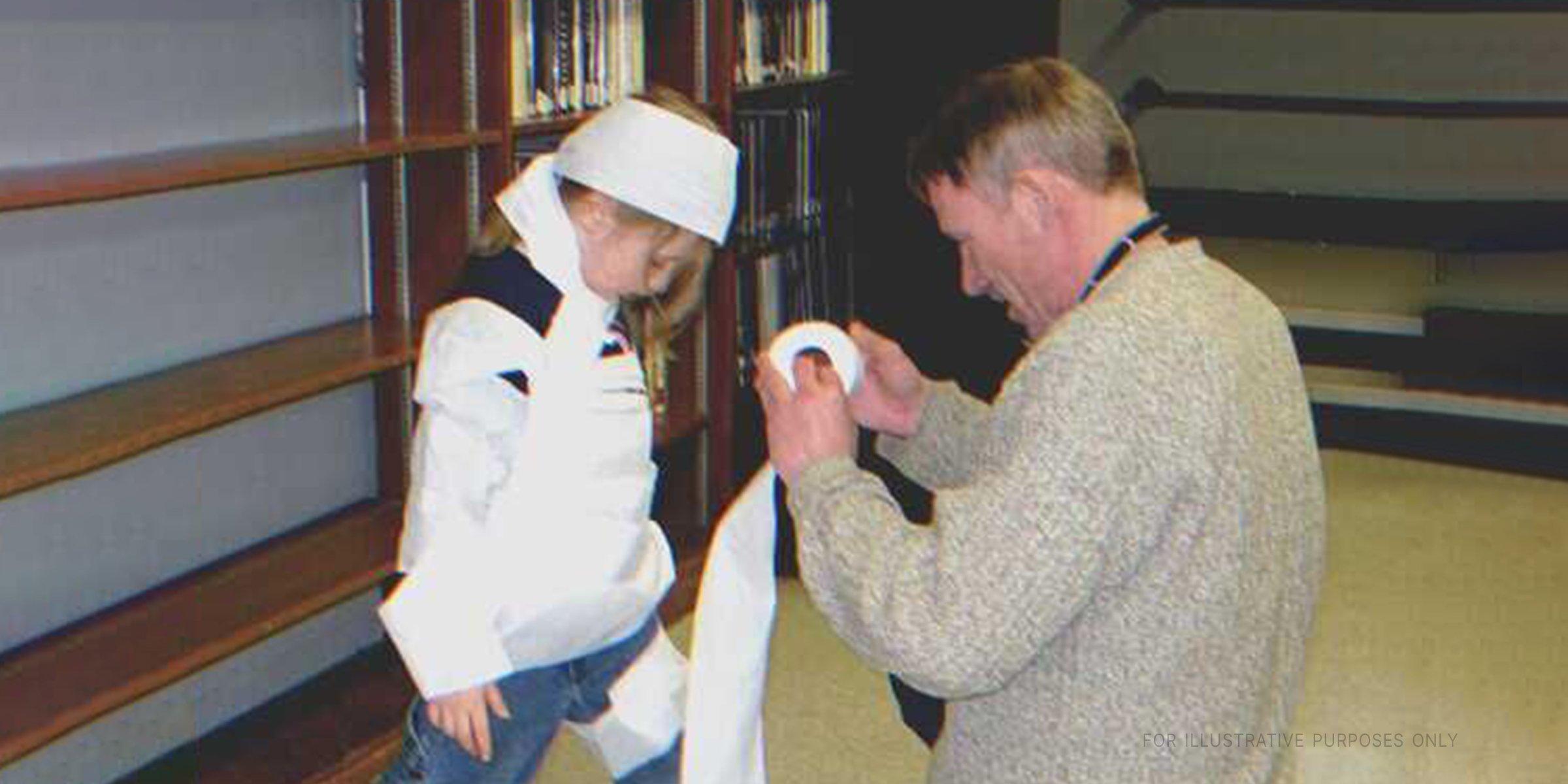 Man dressing up girl for Halloween party using toilet paper | Source: Flickr/Manchester Library (CC BY-SA 2.0)