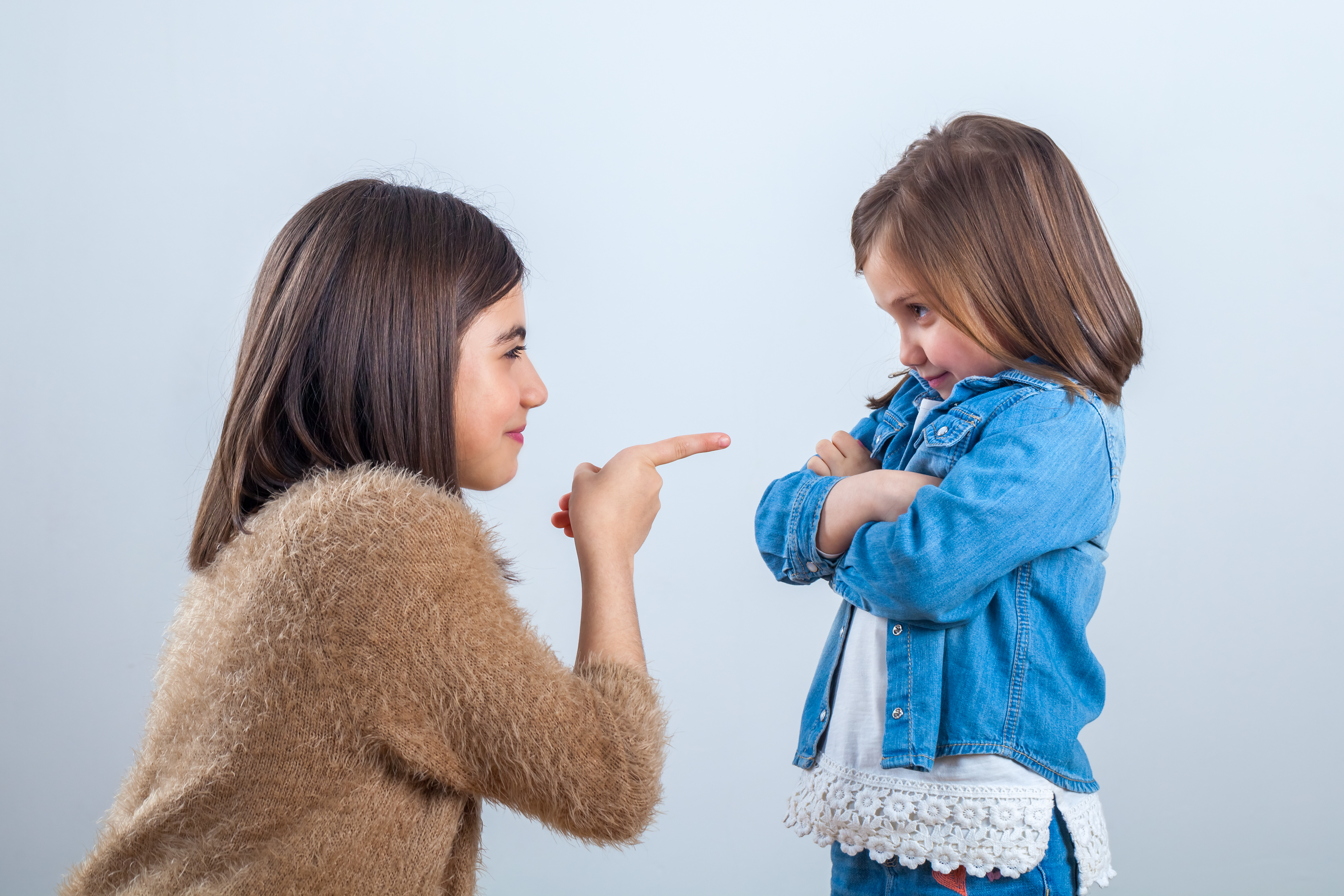 Older sister gives a remark to the younger one with a finger | Source: Getty Images