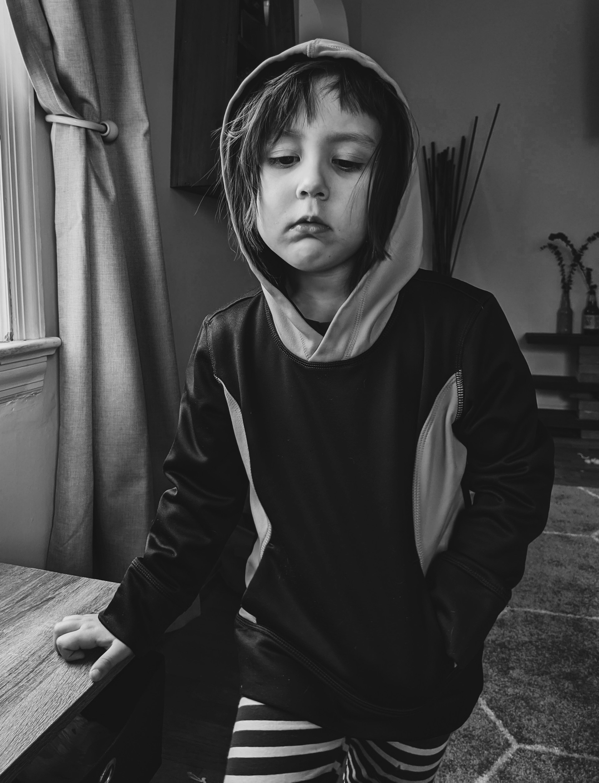 Fotografía en escala de grises de un niño pensativo | Fuente: Unsplash